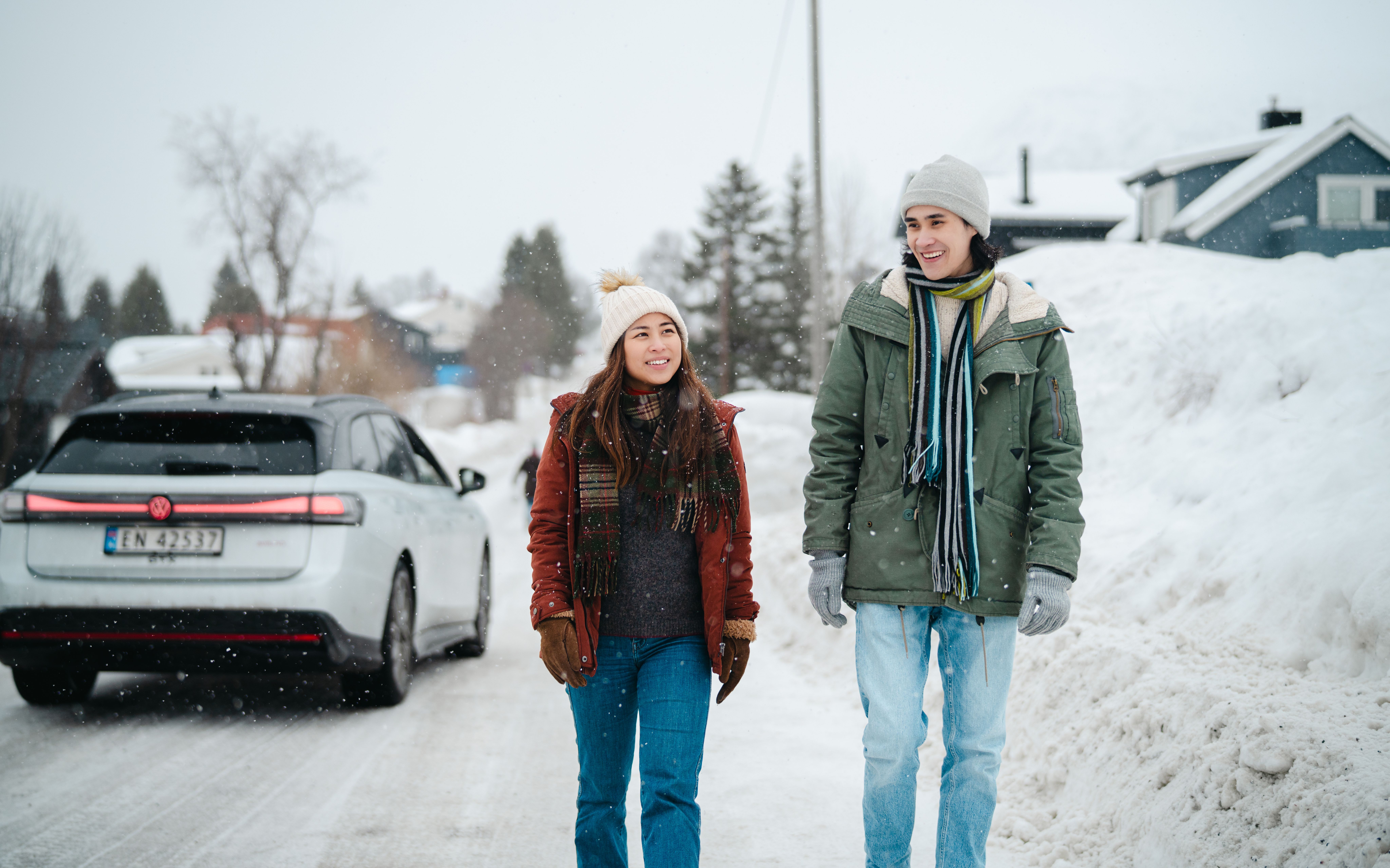 Two tourists walking on the left side of the road.