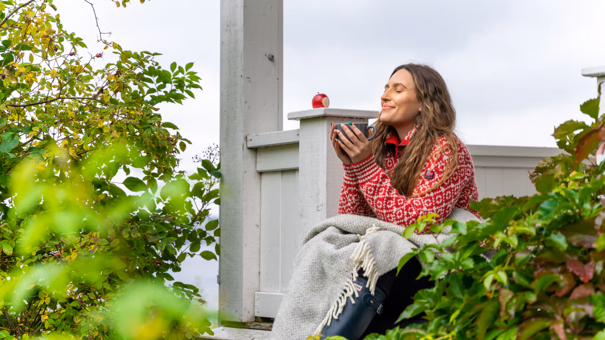 A woman having a good time in the garden at the farm Hoel Gård at Nes, Eastern Norway.