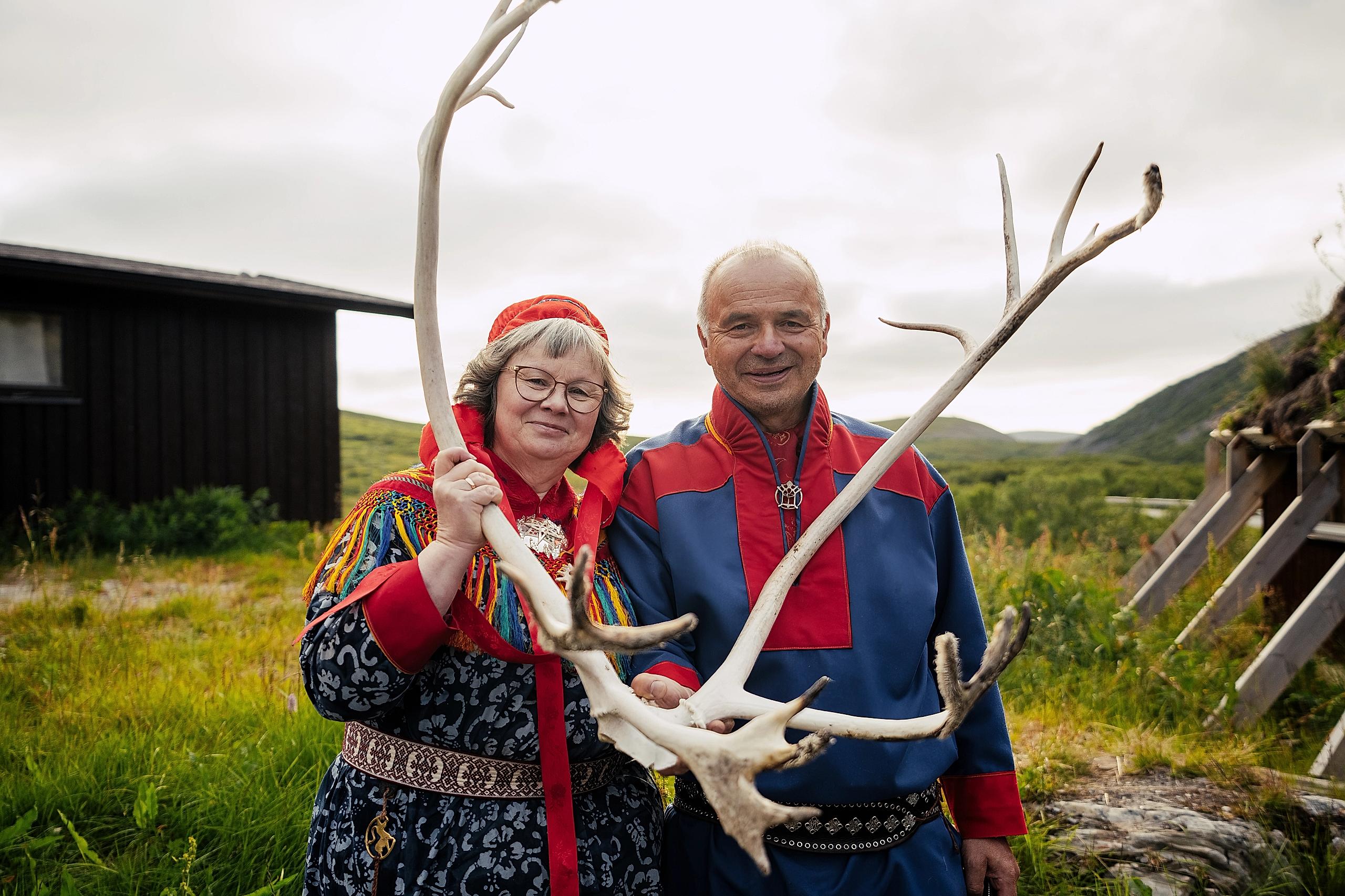 Two Sami people holding reindeer antlers