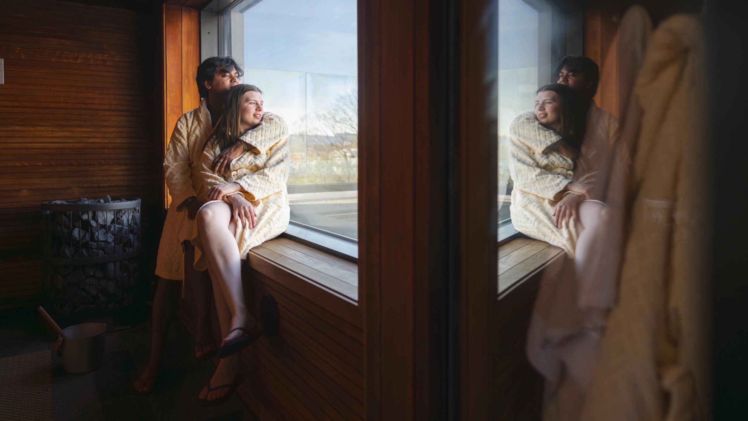 A couple enjoying the view from inside a sauna