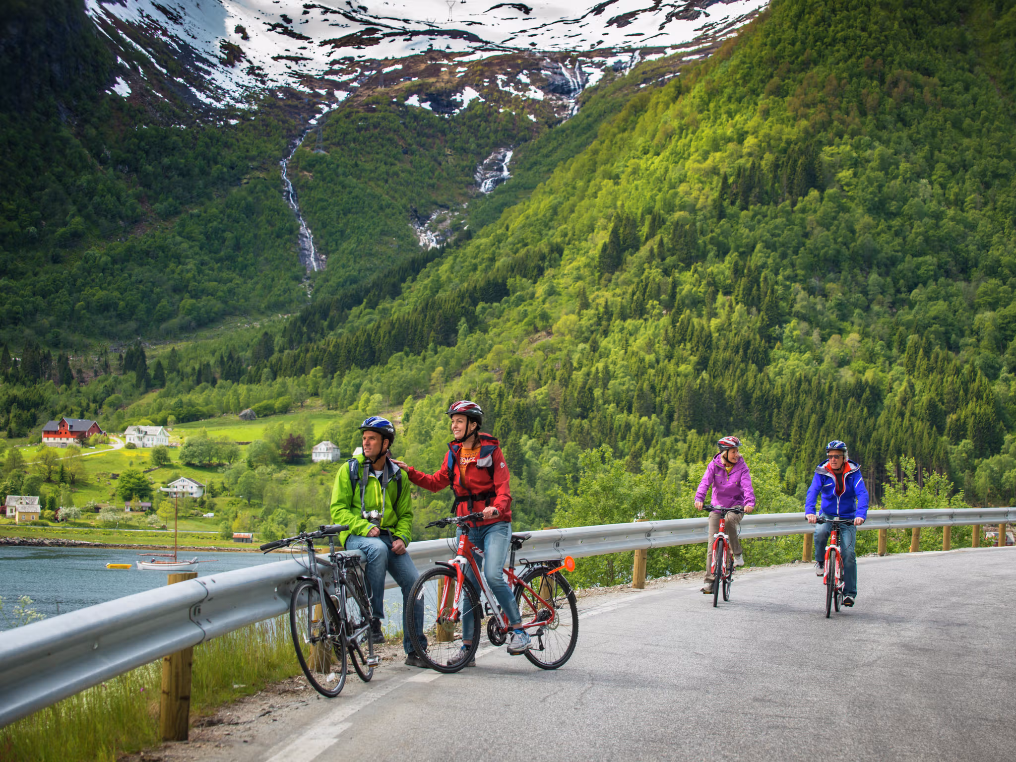 People cycling on a road in Balestrand, Fjord Norway