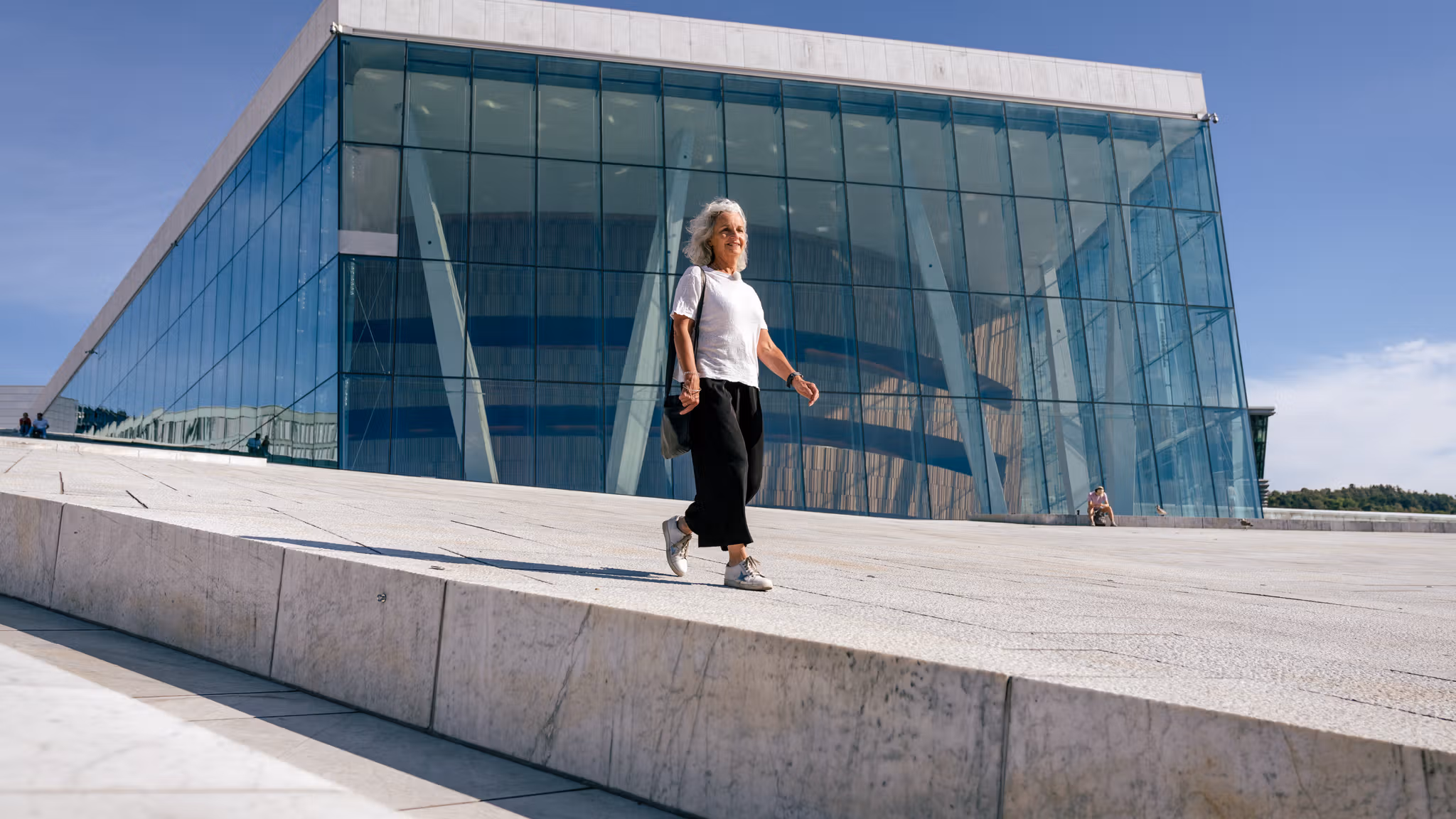 A woman walking over Oslo Opera House