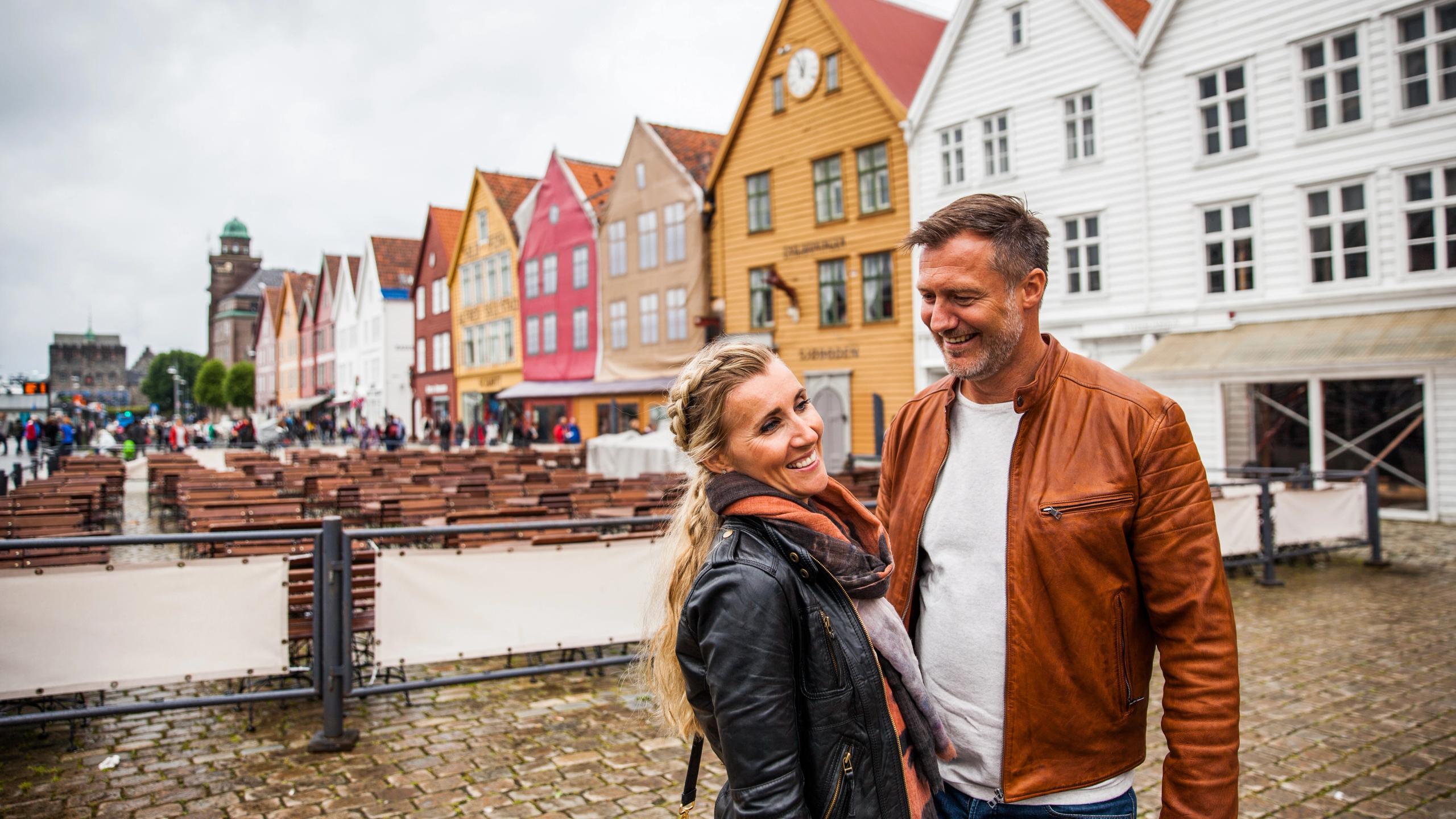 Et muntert par smiler fra bryggen i Bergen på Vestlandet