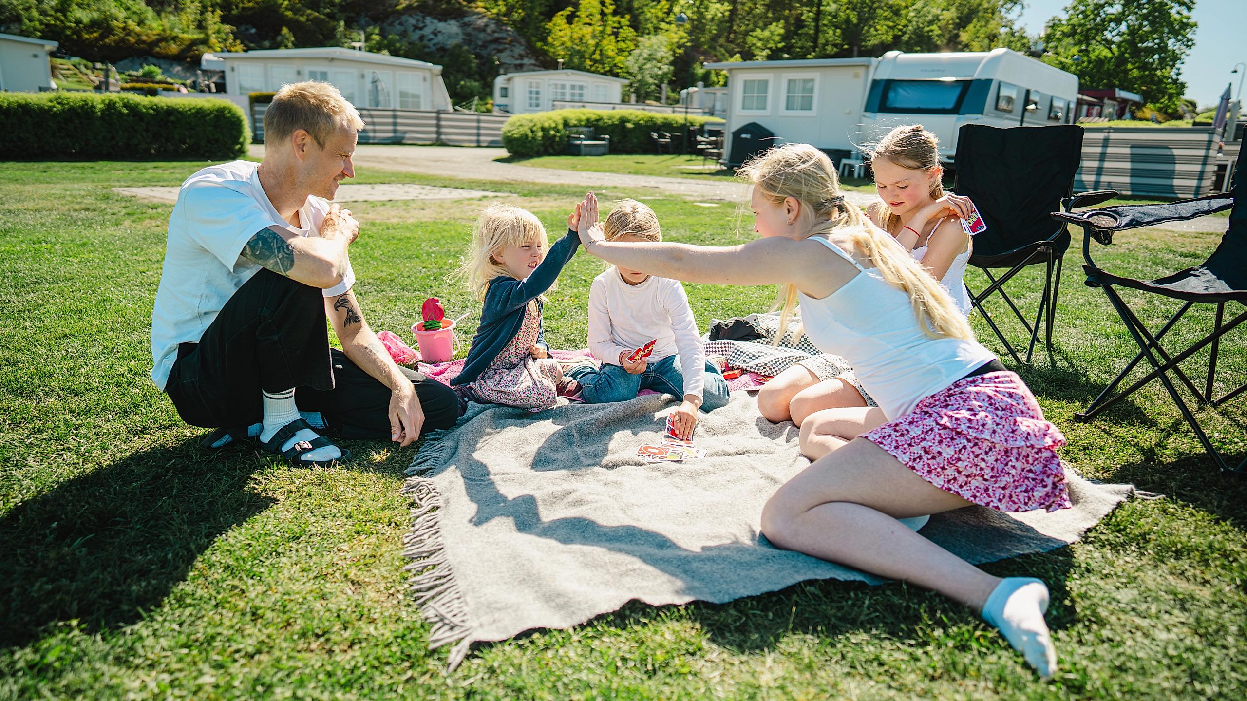 A family playing a card game on a camping holiday