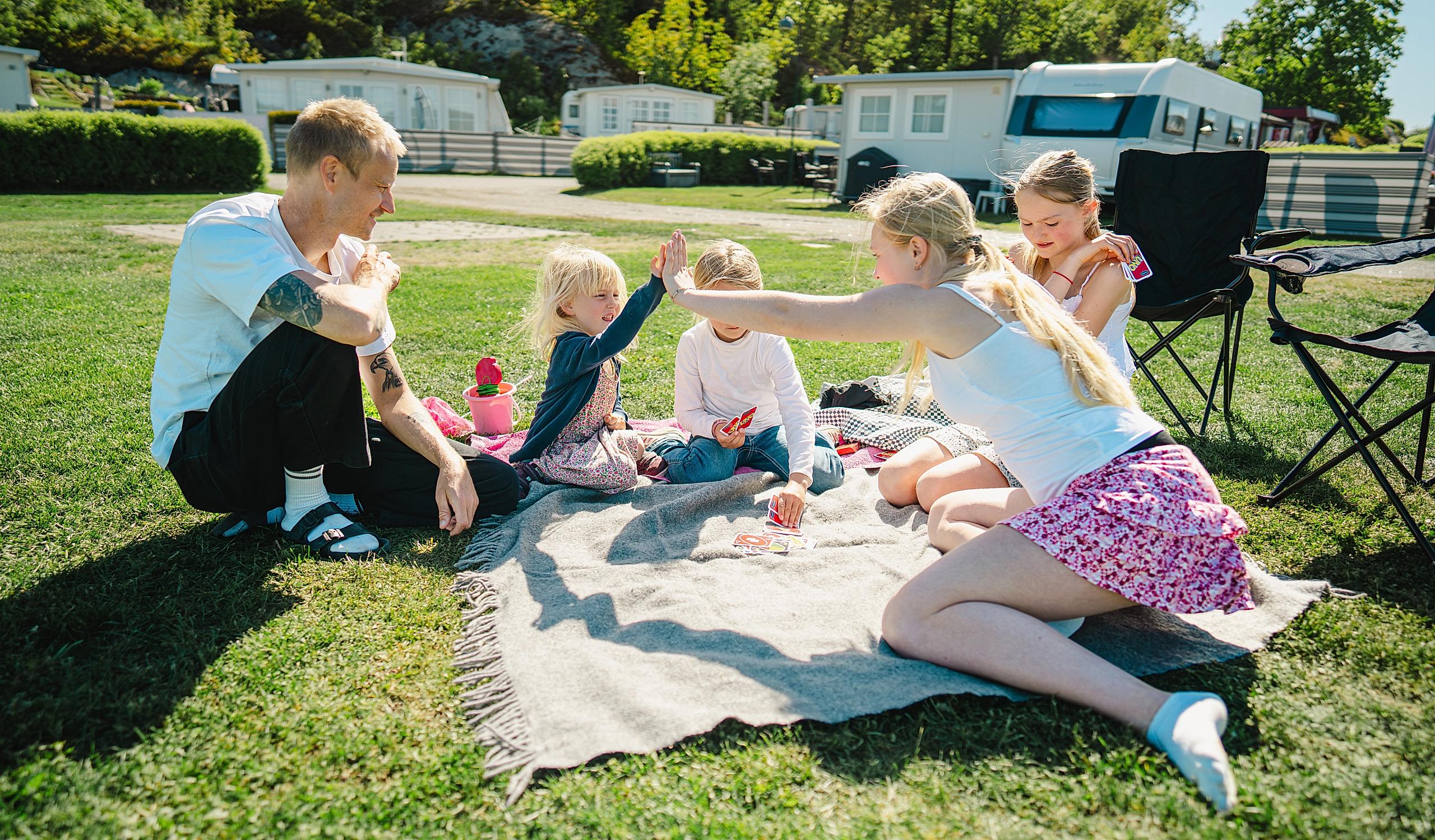 A family playing a card game on a camping holiday