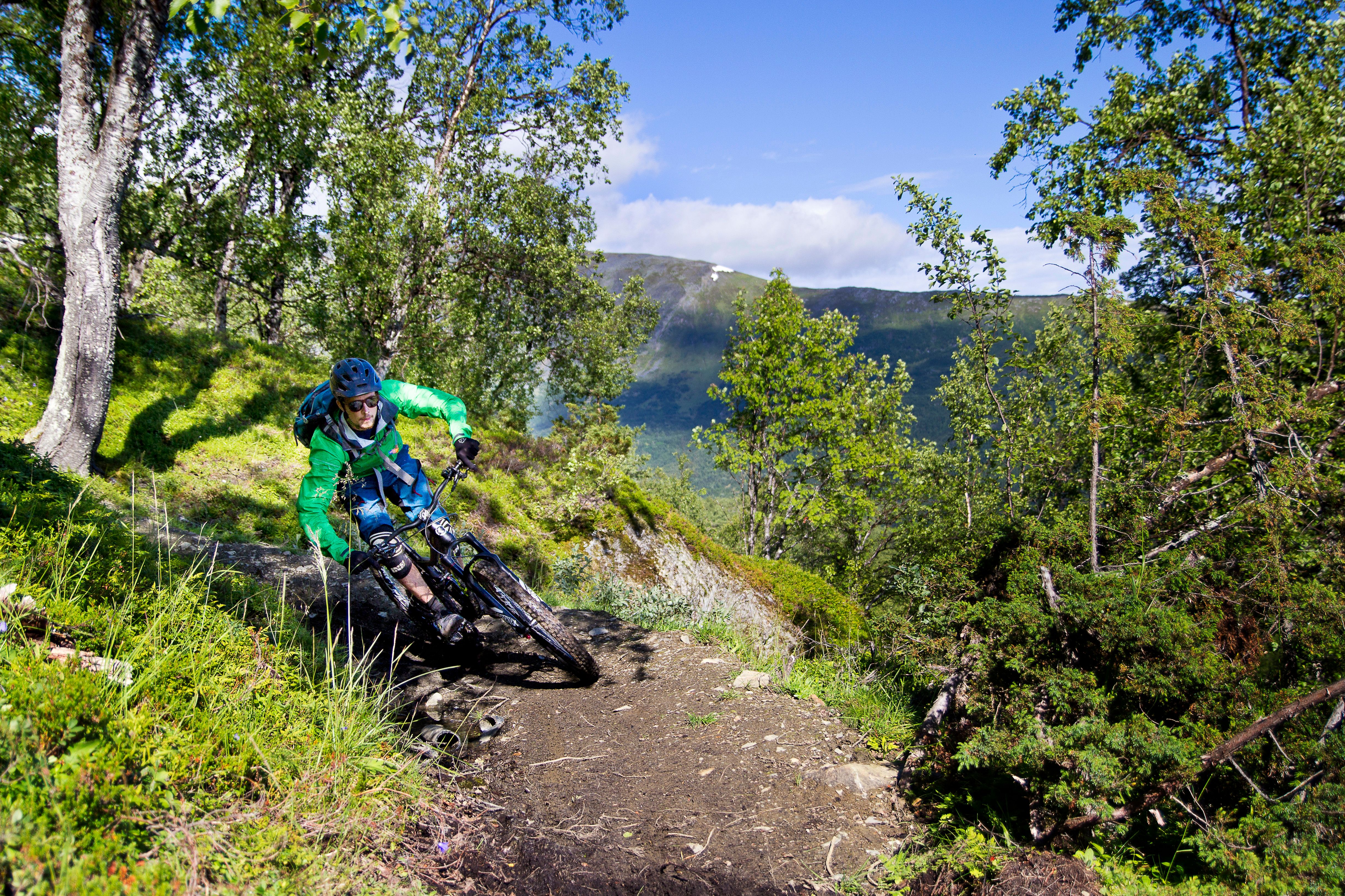 A man mountain biking in the Lyngenfjord region in Northern Norway, in the mountains