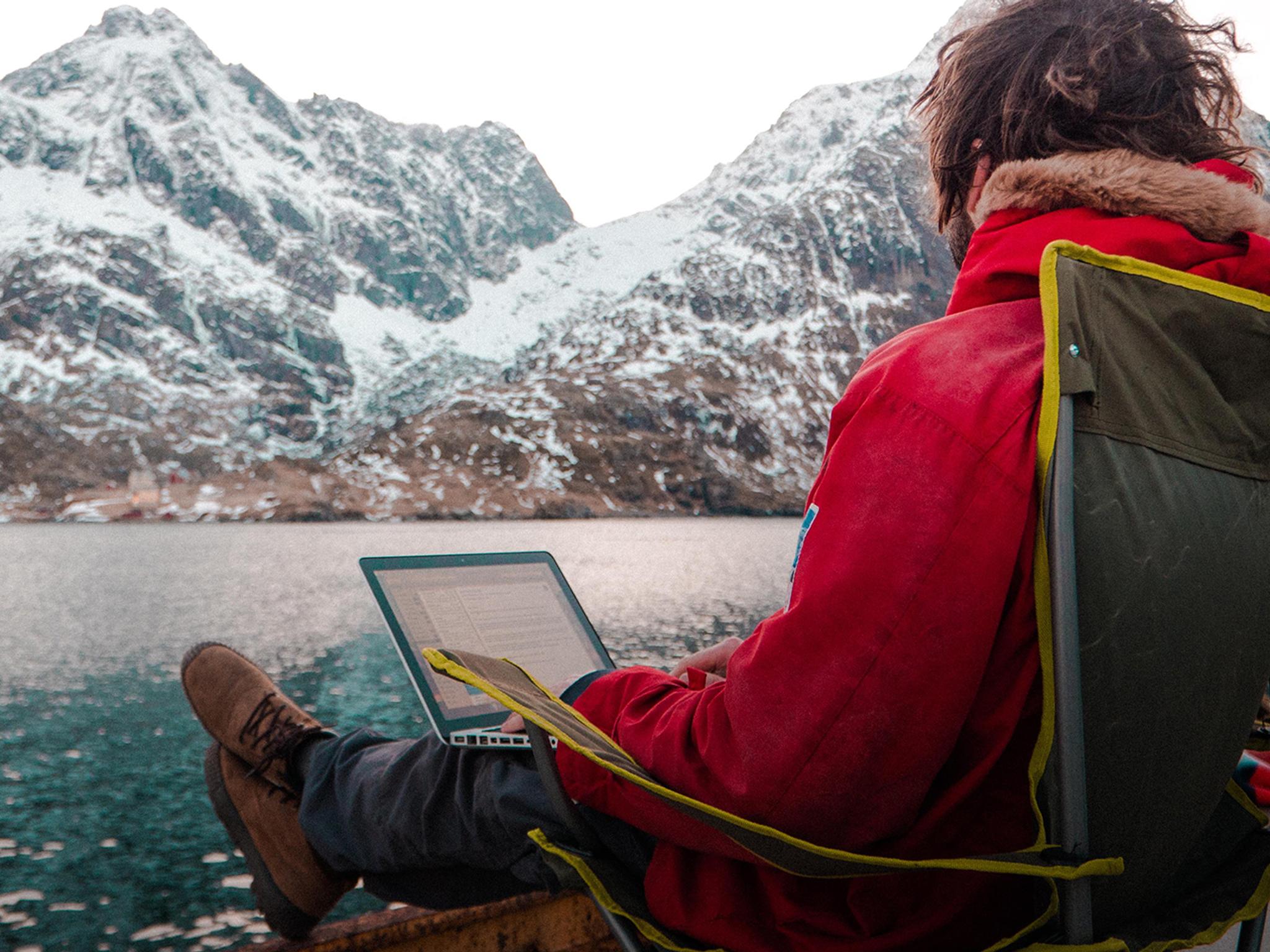 En mann jobber utendørs på Arctic Coworking Lodge i Lofoten, Nord-Norge