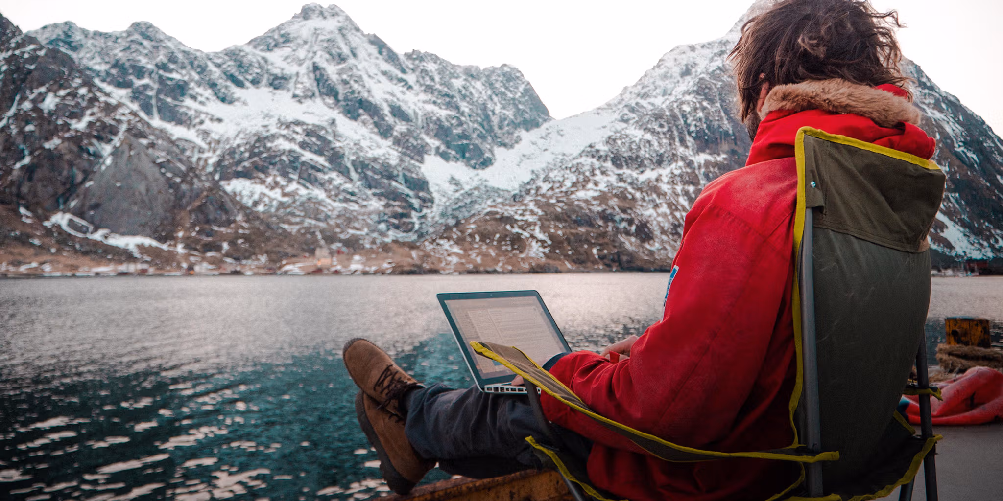 A man working outdoors by the sea at the Arctic Coworking Lodge in Lofoten, Northern Noway