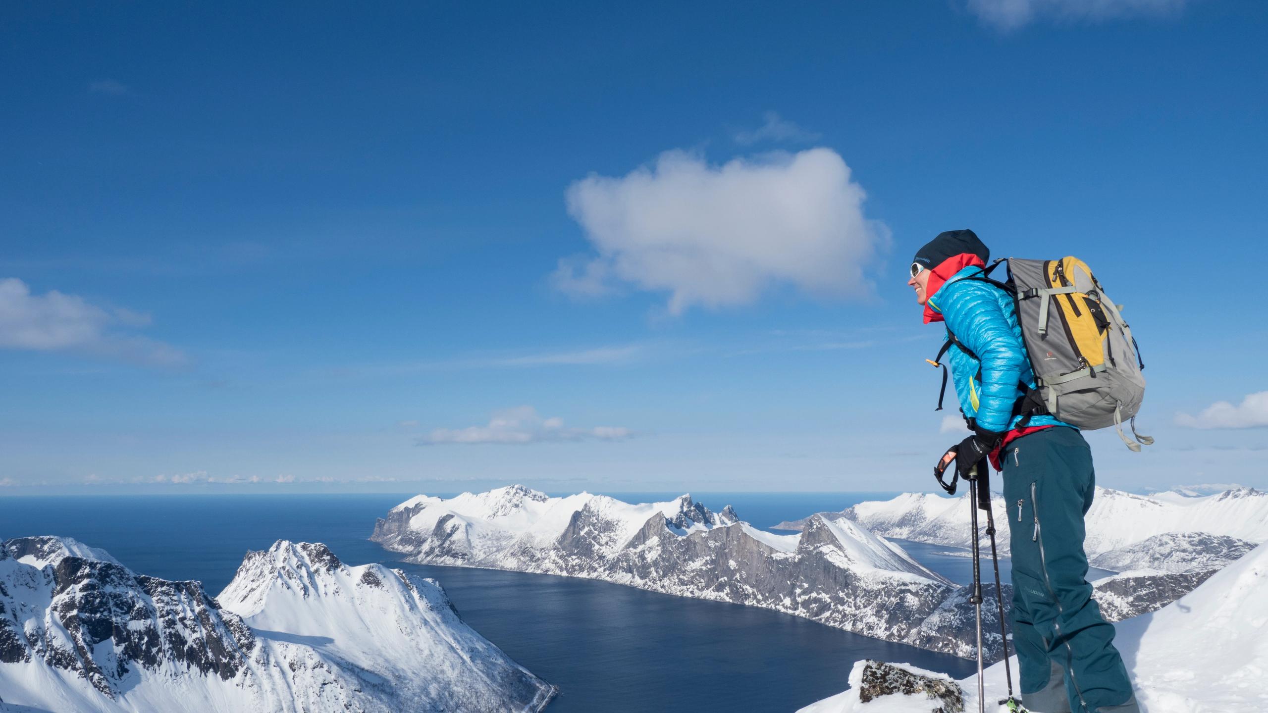 En dame nyter utsikten fra toppen av et fjell på Senja i Nord-Norge om vinteren