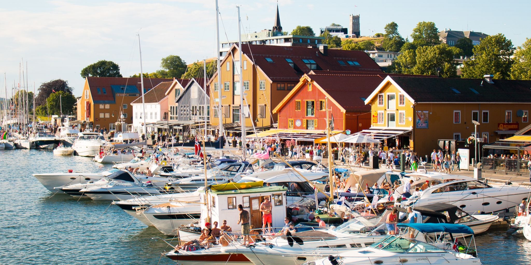 Båtar och människor en solig dag i hamnen i Tønsberg, Vestfold i regionen Østlandet (östra Norge)