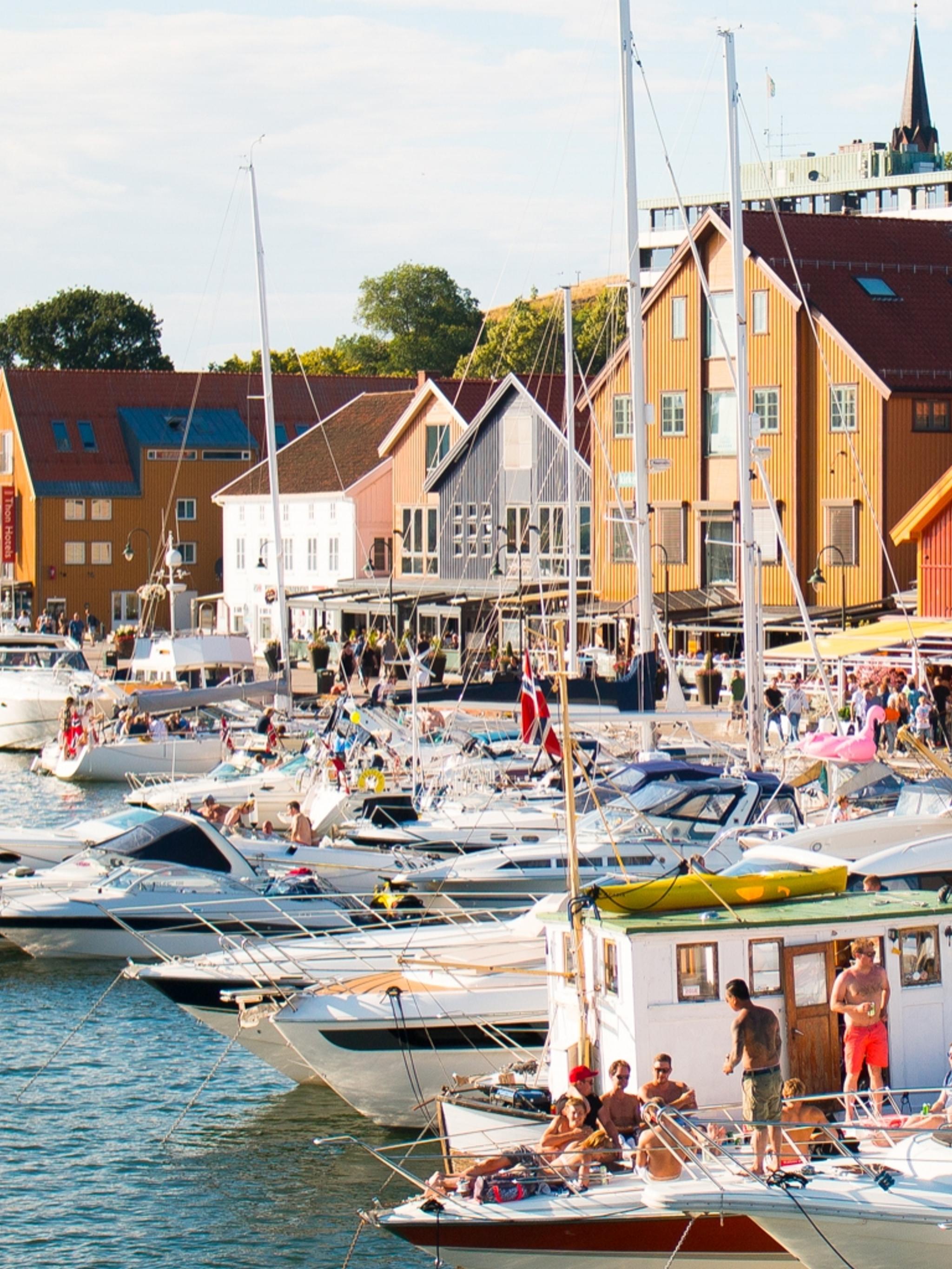 Båtar och människor en solig dag i hamnen i Tønsberg, Vestfold i regionen Østlandet (östra Norge)