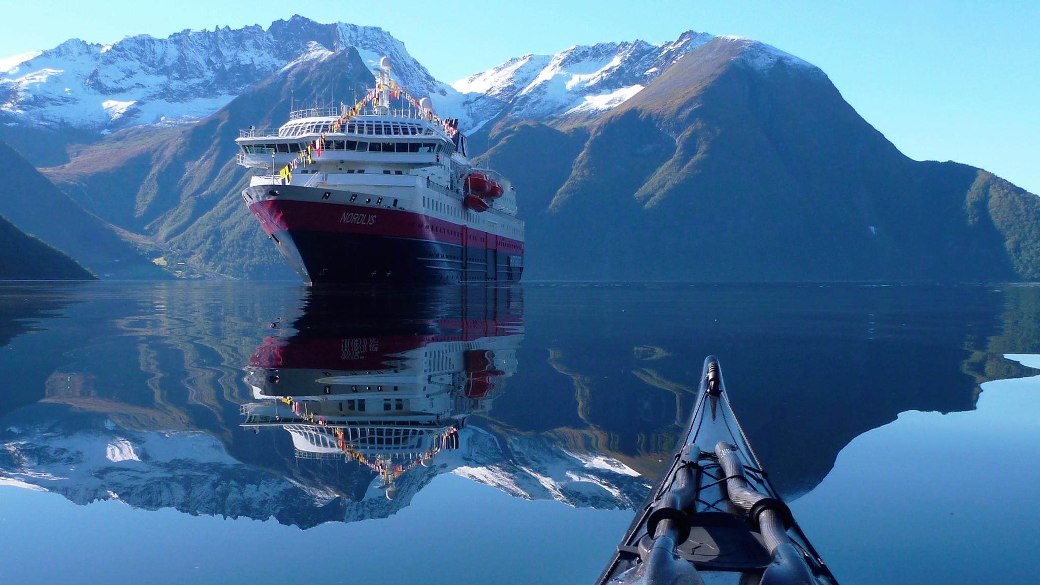 View of the Hurtigruten ship MS Nordlys from a kayak at Hjørundfjorden in Fjord Norway