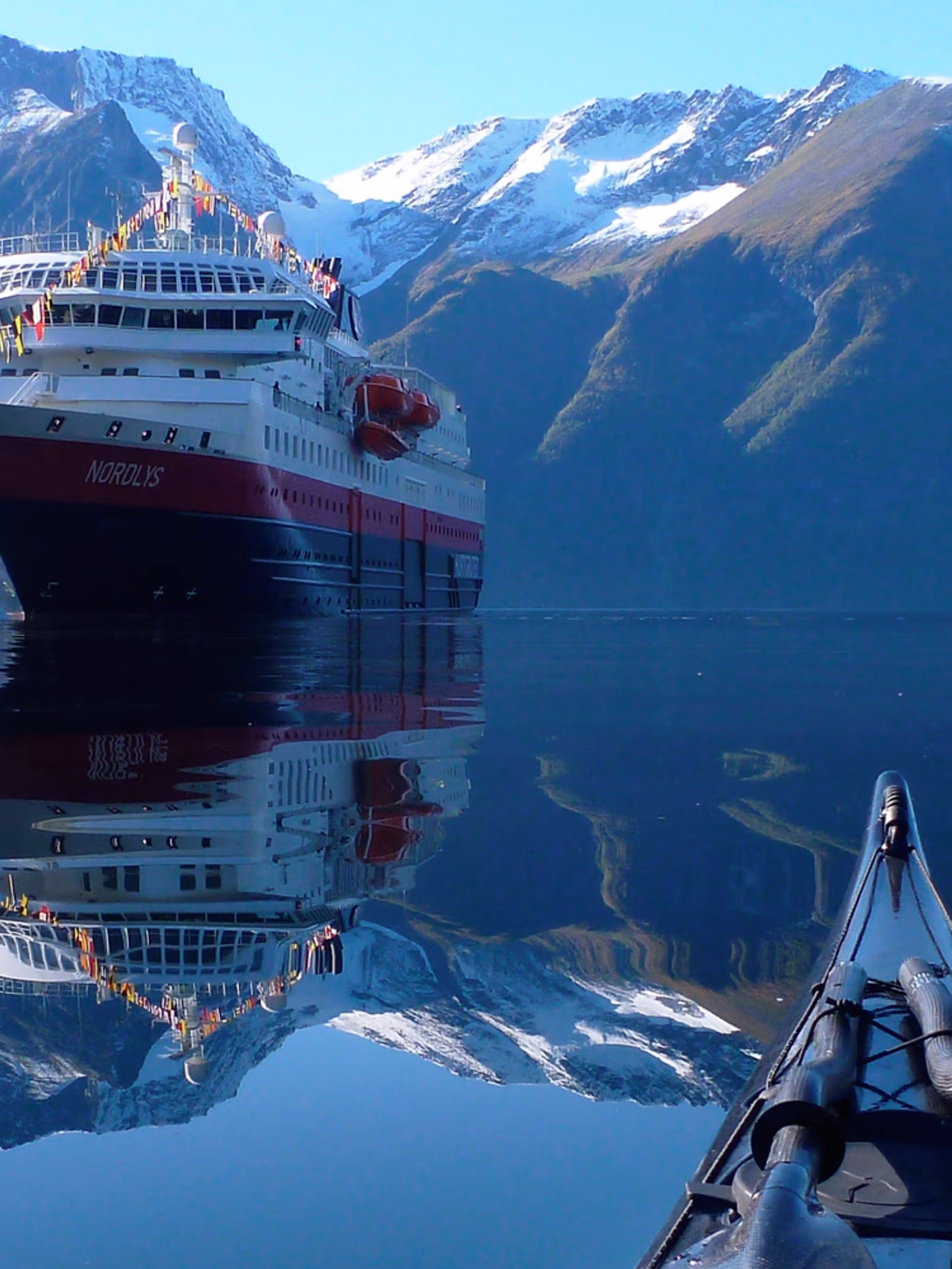 View of the Hurtigruten ship MS Nordlys from a kayak at Hjørundfjorden in Fjord Norway