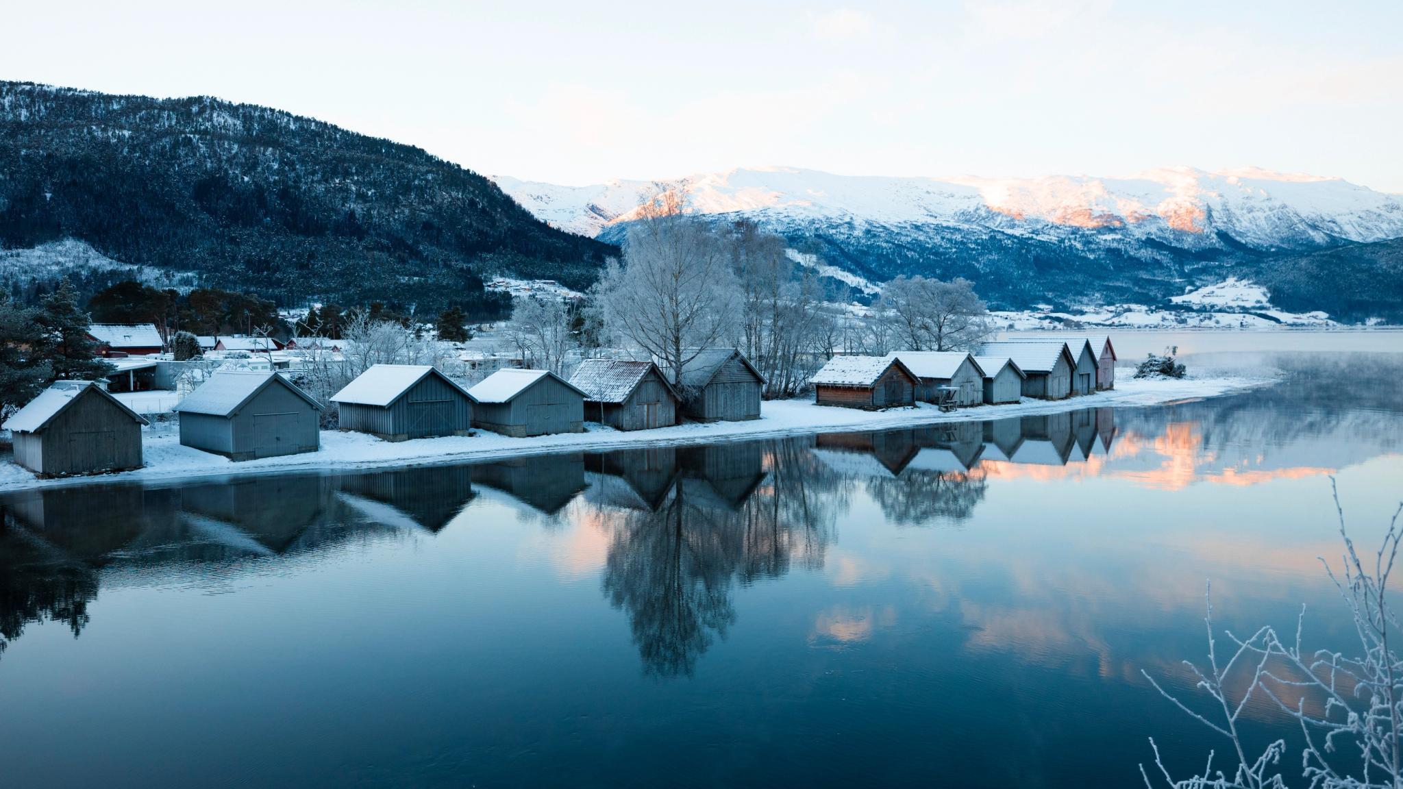 Wooden houses along a fjord in winter