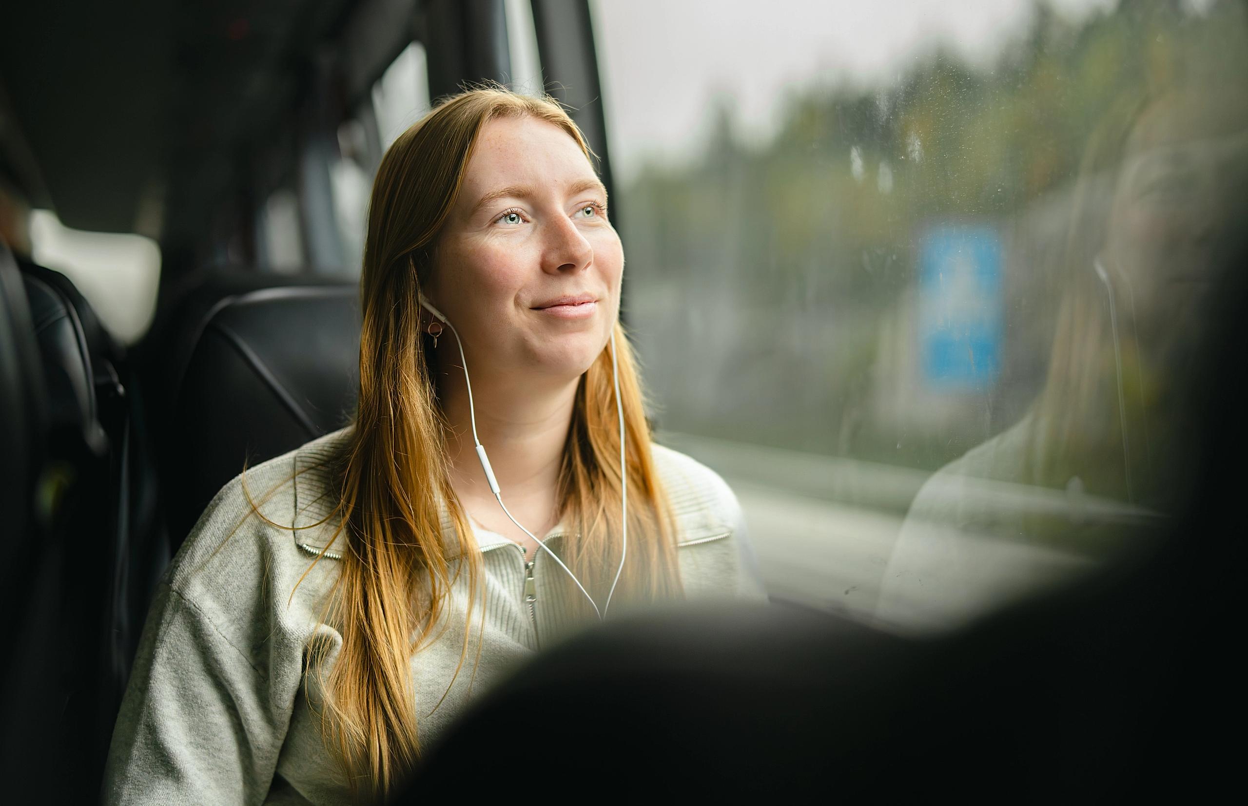 A woman on a bus looking out the window.