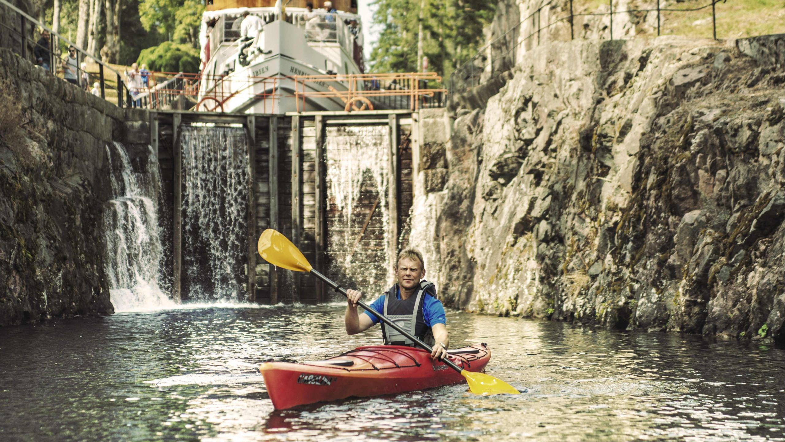 A man paddling in a kayak on the Telemark canal in Eastern Norway