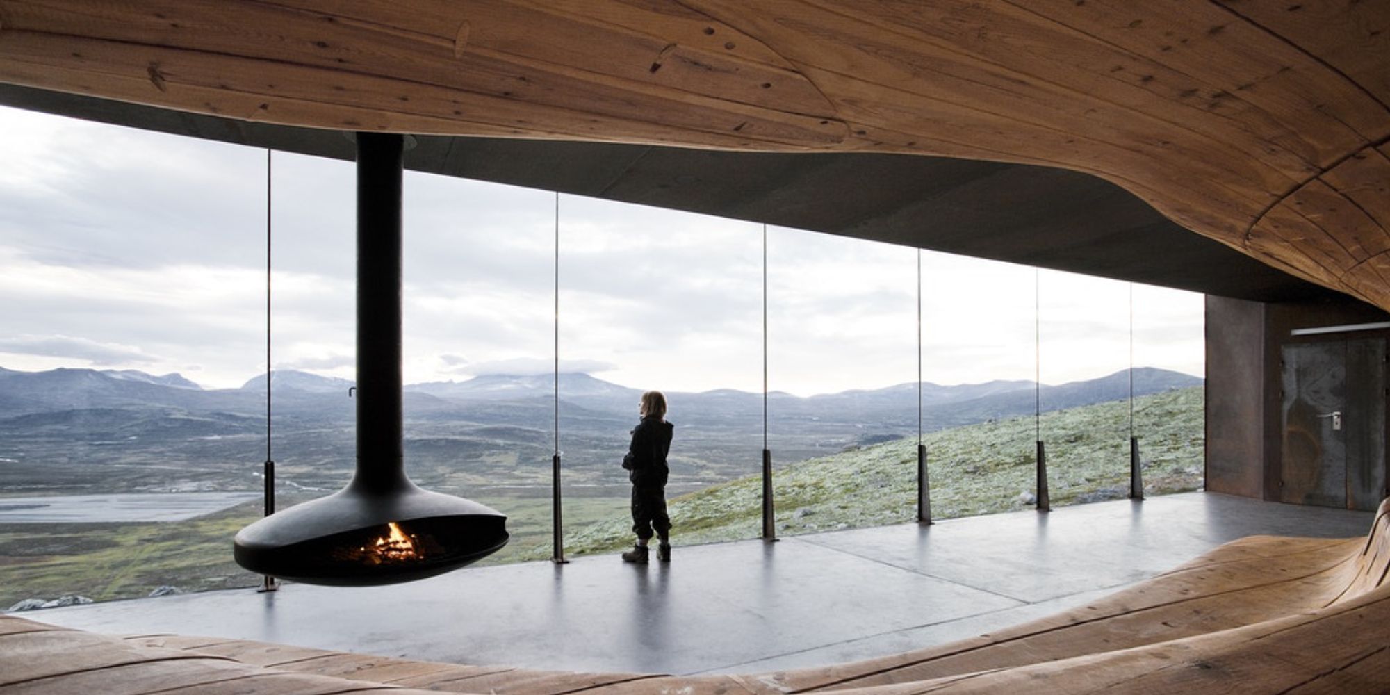 A person looking at the view from inside the Viewpoint Snøhetta in Hjerkinn.