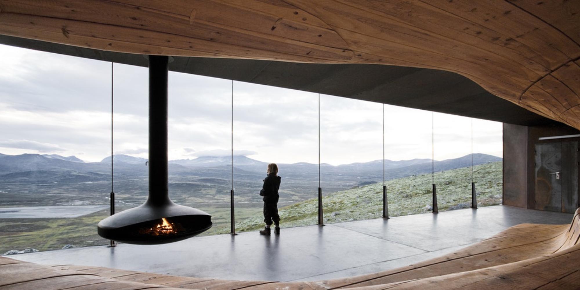 A person looking at the view from inside the Viewpoint Snøhetta in Hjerkinn.