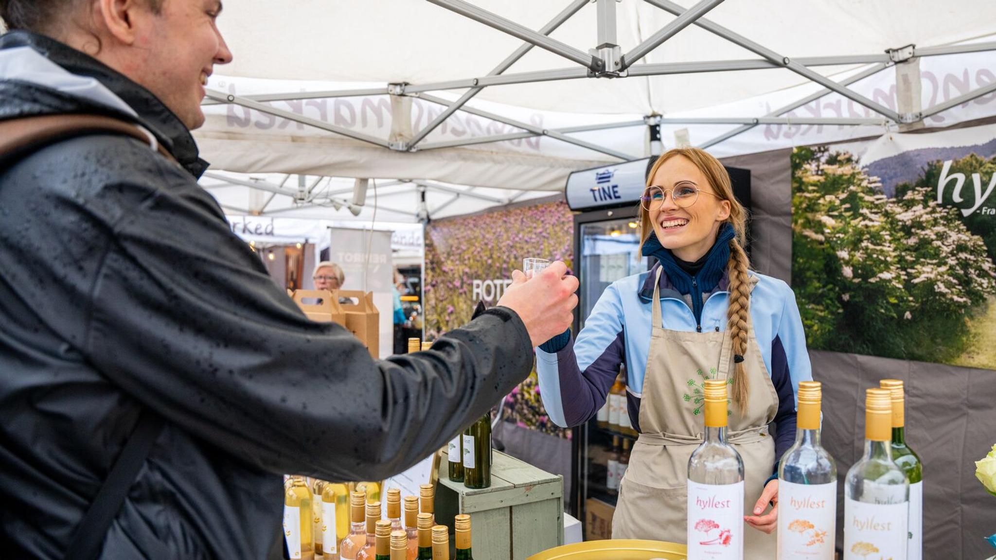 En mann og en kvinne skåler med hylleblomstdrikk på Matstreif matfestival i Oslo