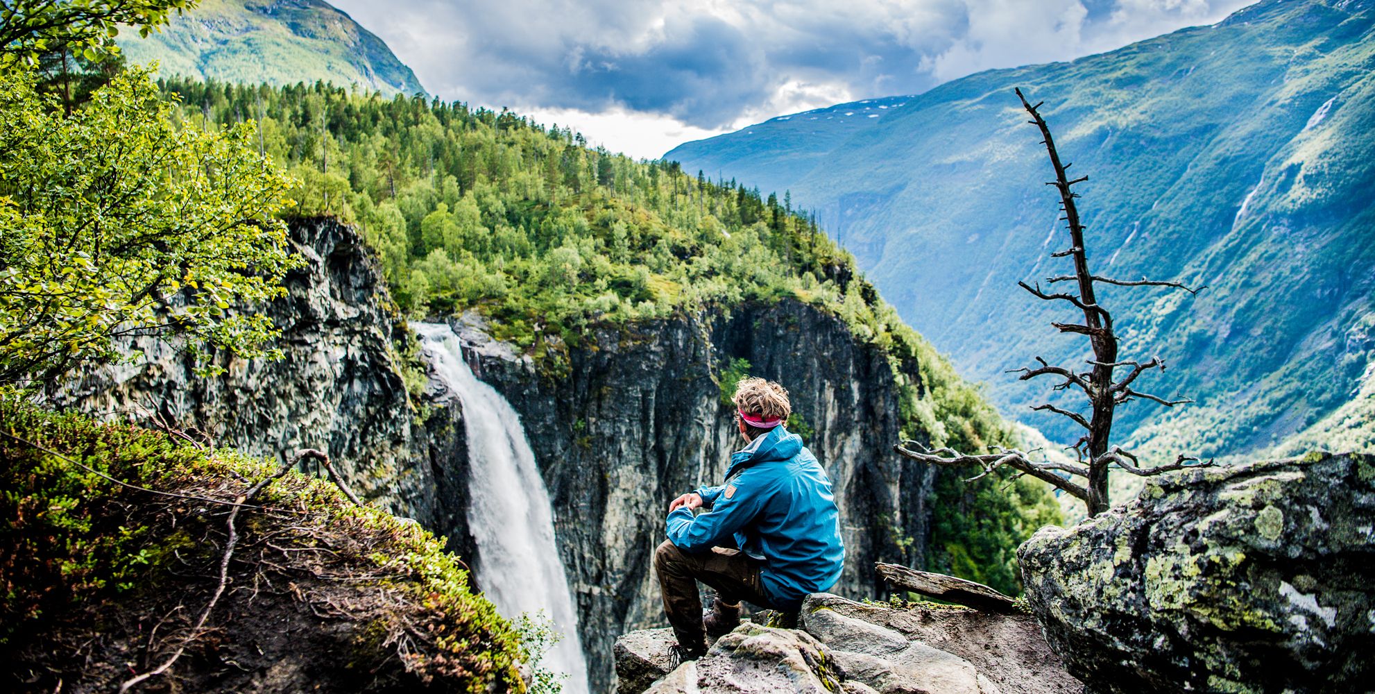 Escursionista ammira la vista della cascata Vettisfossen a Utladalen sui monti Jotunheimen, Norvegia