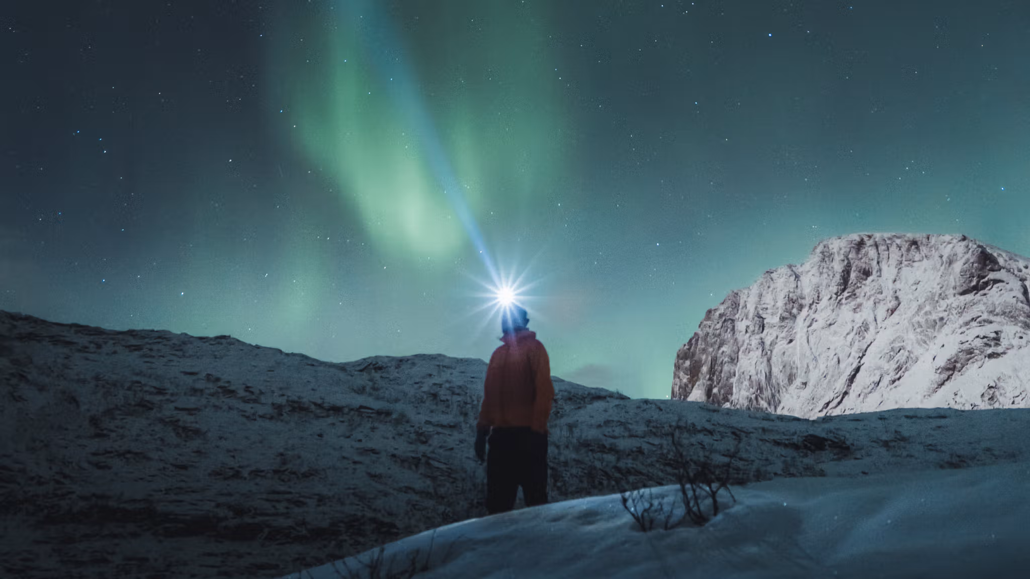 Man watching the northern lights over Mefjordsletta, Senja