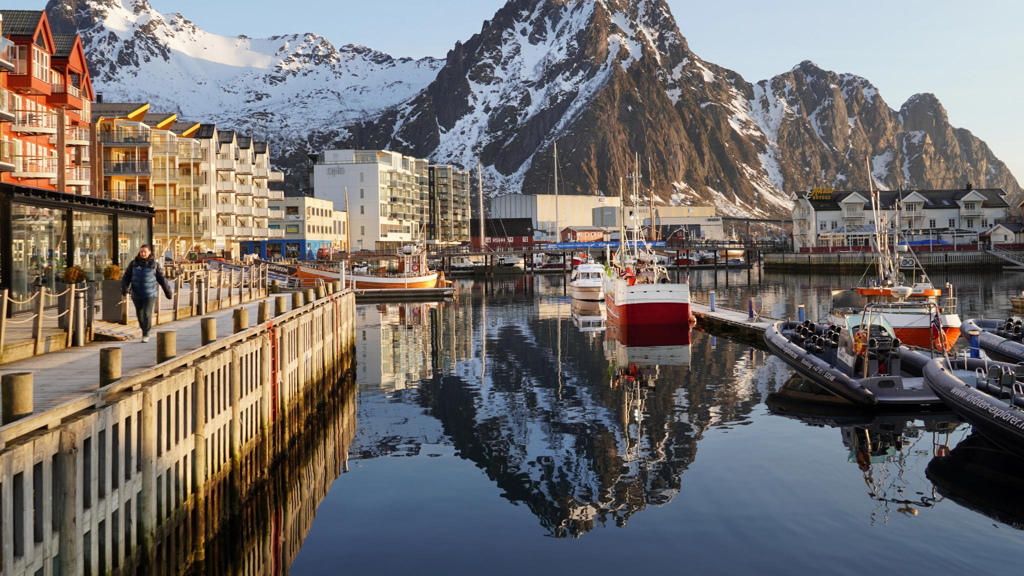 A harbour in low sunlight and high mountains behind