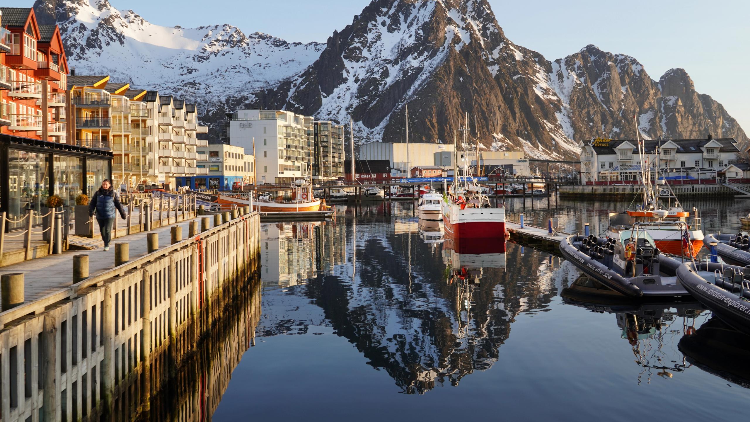 A harbour in low sunlight and high mountains behind