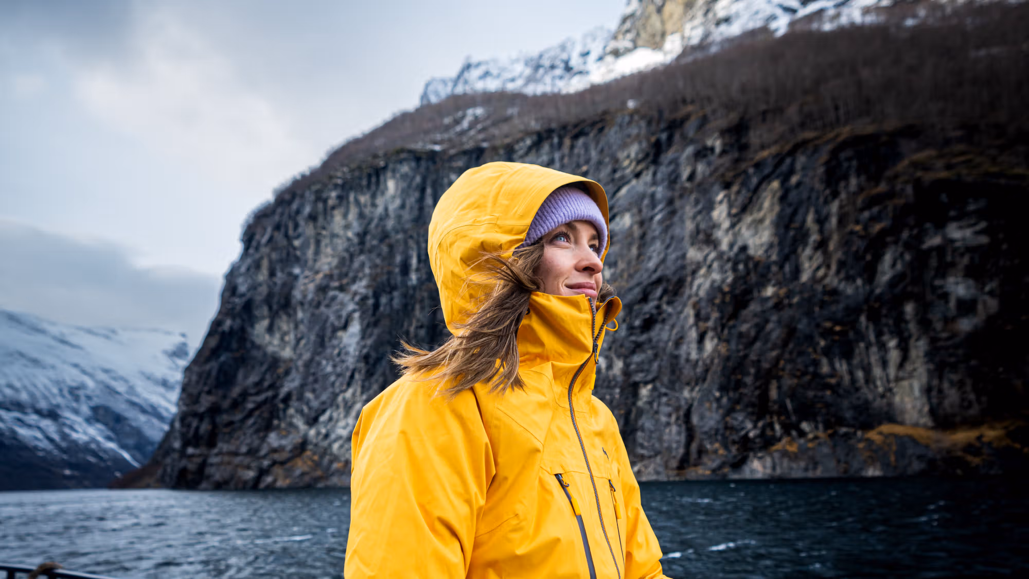 Woman enjoying the view from Geiranger fjordservice cruise boat in Geiranger
