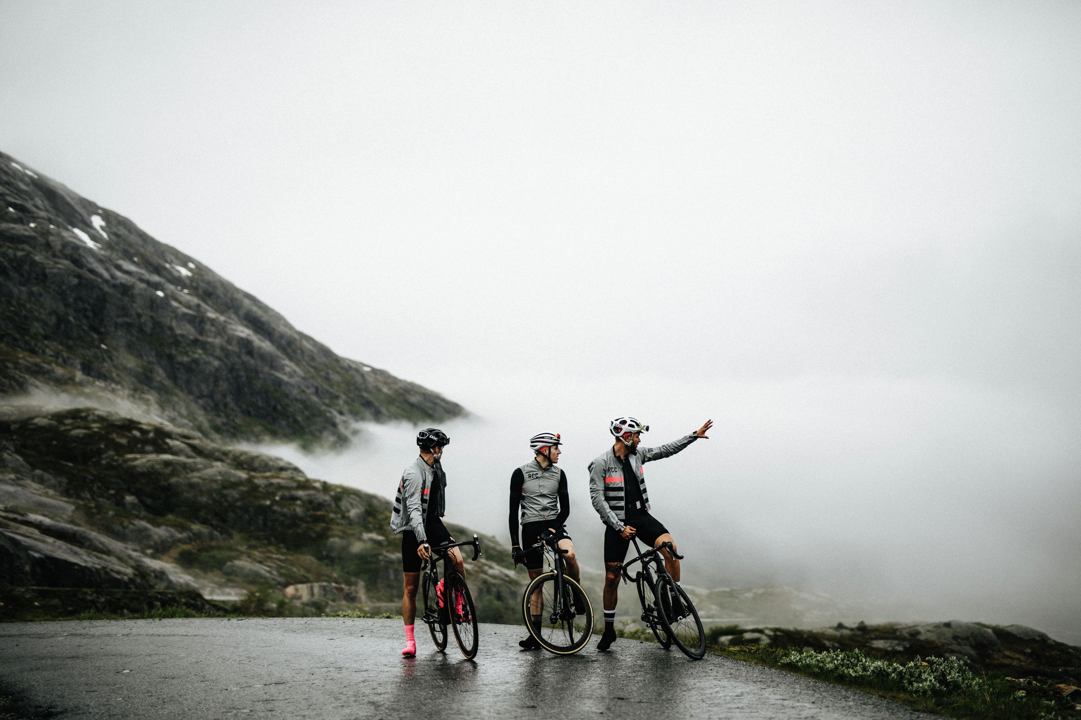 Three road cyclists in fog in Fjord Norway