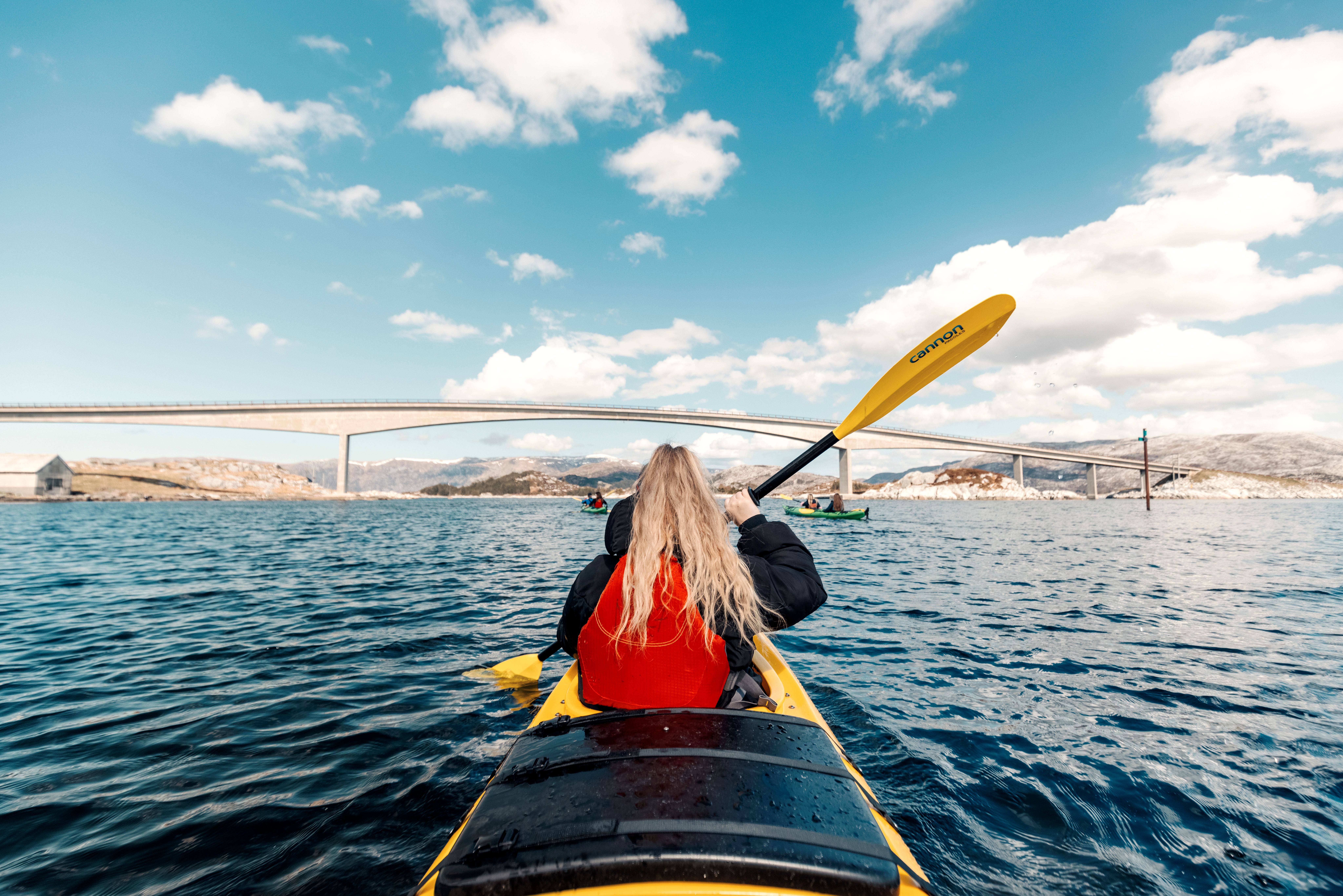 A woman kayaking on a fjord.