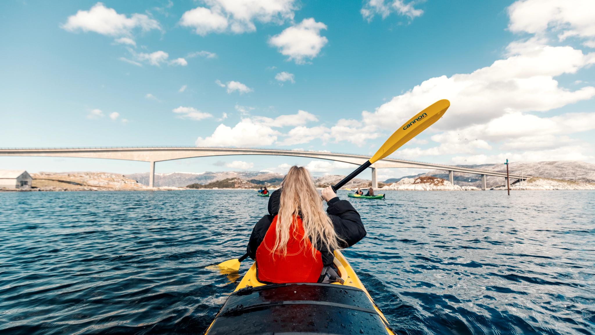 A woman kayaking on a fjord.