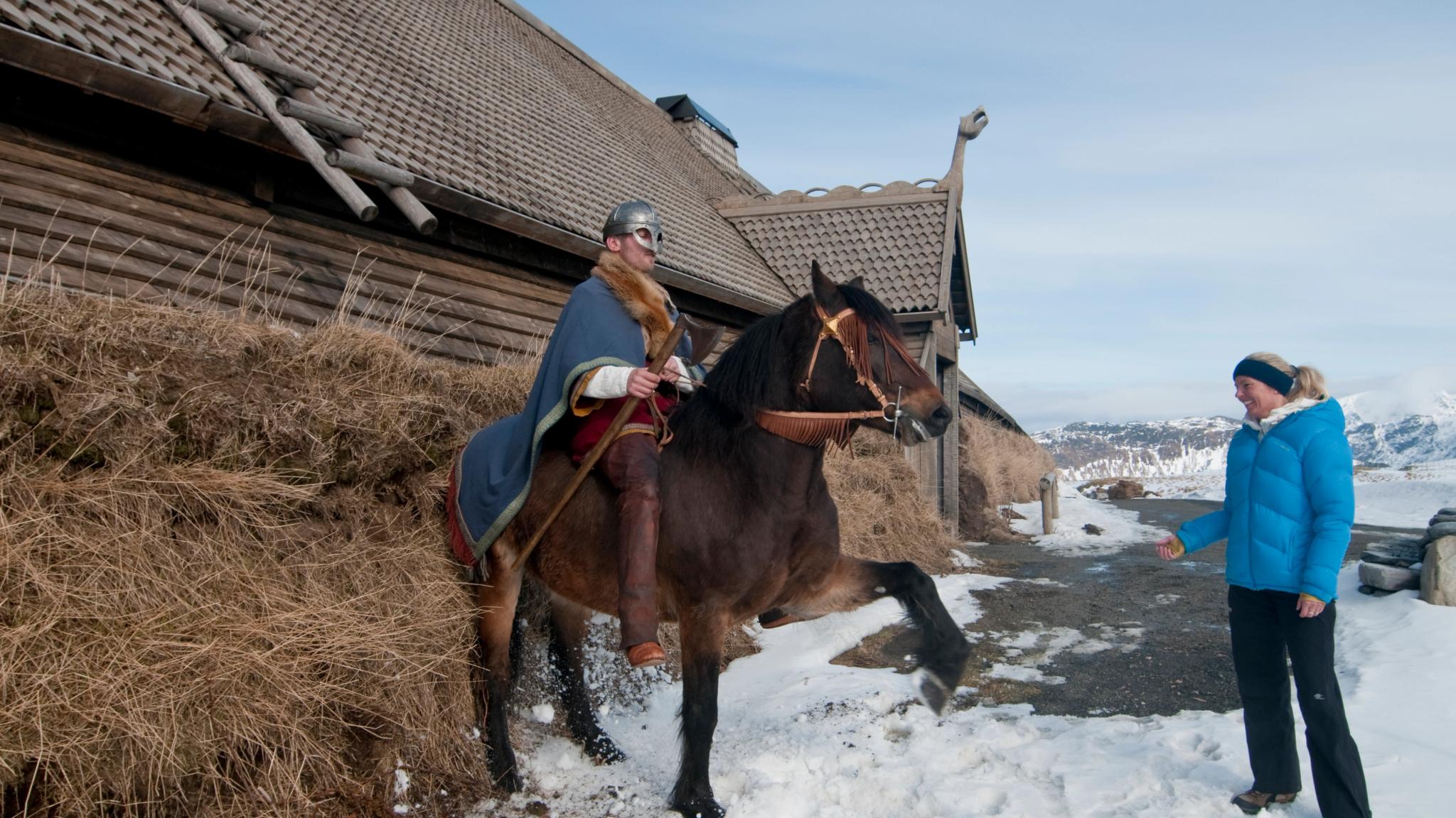 A Viking on his horse is posing for visitors at Lofotr Viking Museum in Lofoten, Northern Norway