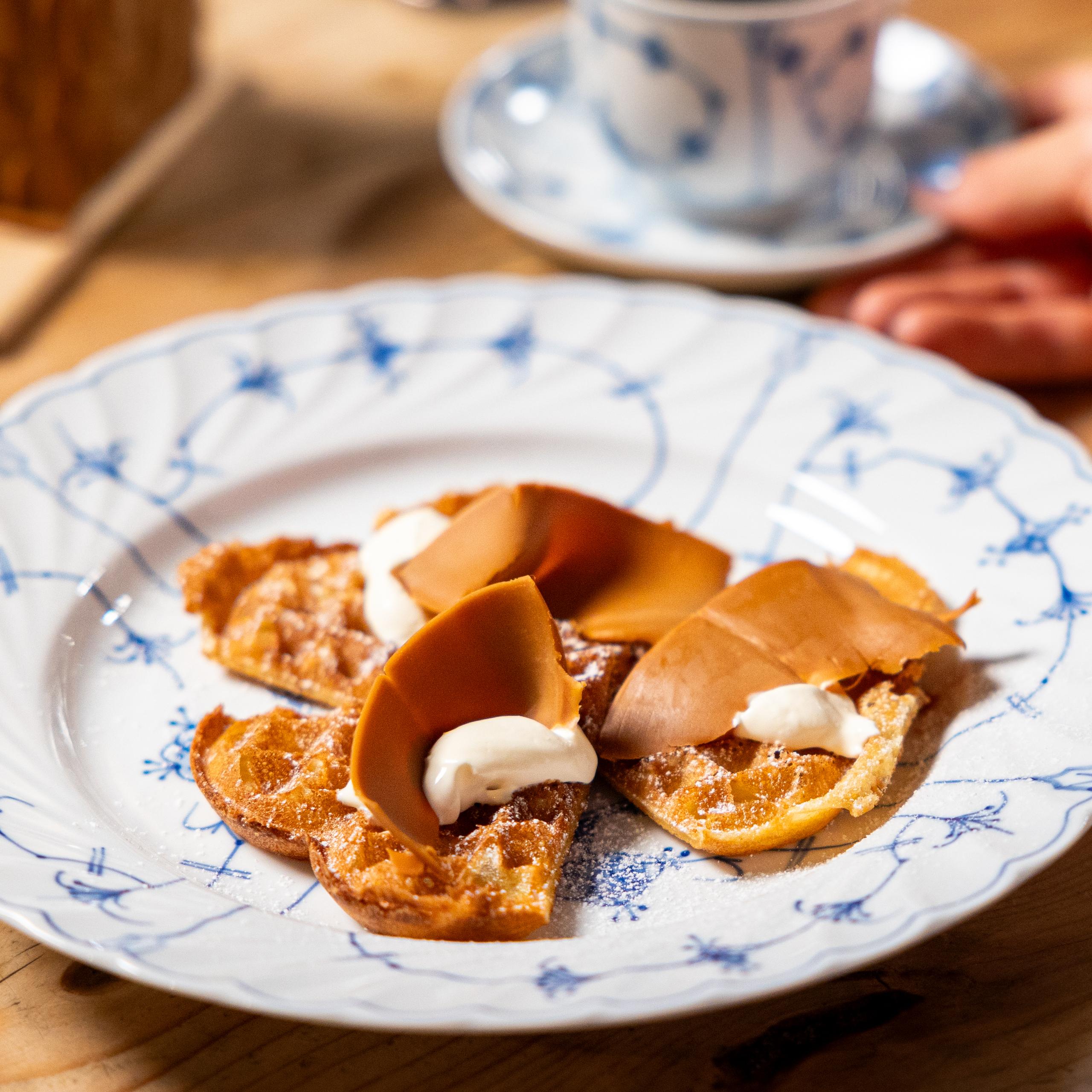 En vaffel med brunost på en tallerken.