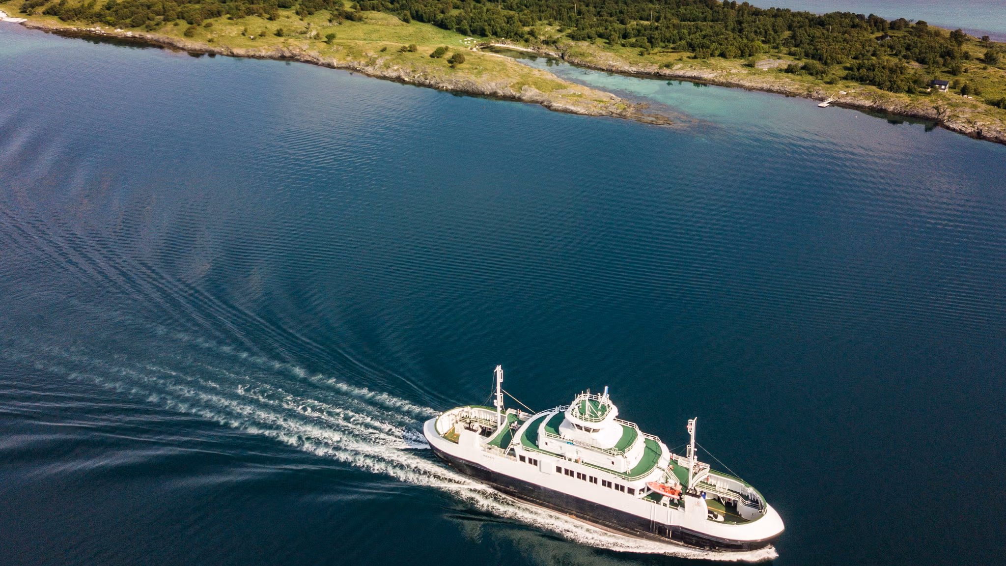 A ferry in travelling along the Helgeland coast in Northern Norway. In the background: the mountain range The seven sisters.