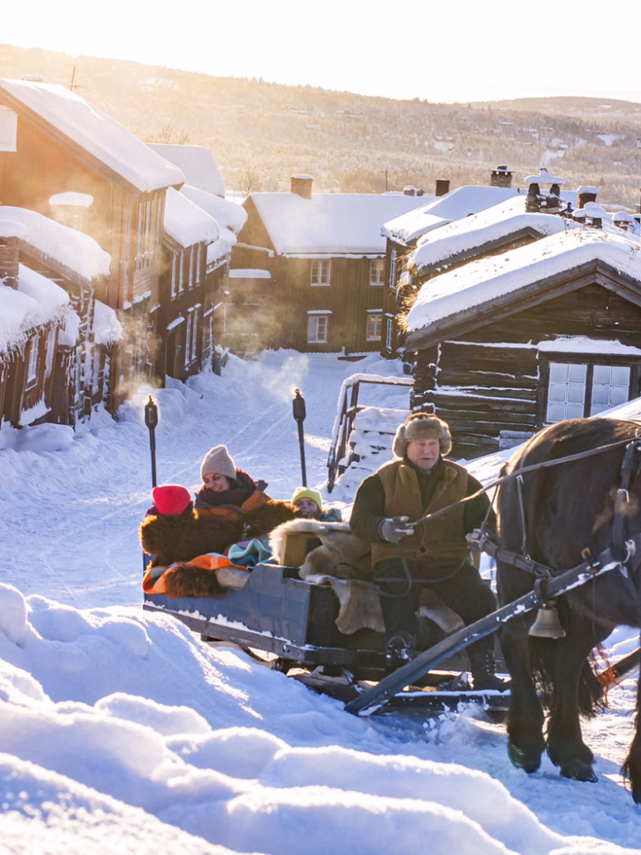 Three people riding a horse and sleigh at Røros a cold winter day