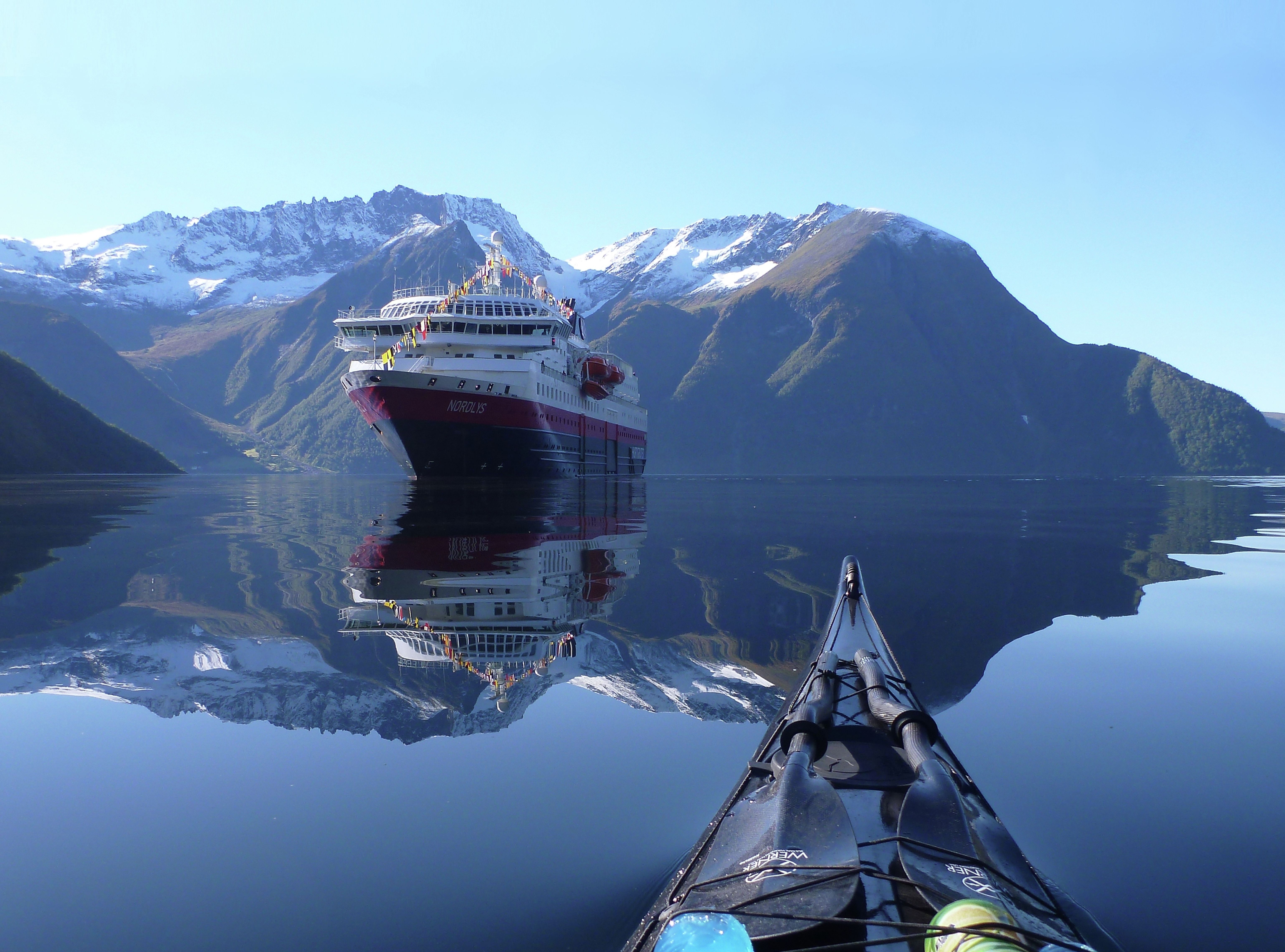 Le bateau MS Nordlys de la flotte Hurtigruten, vu d’un kayak sur le Hjørundfjorden en Norvège des Fjords