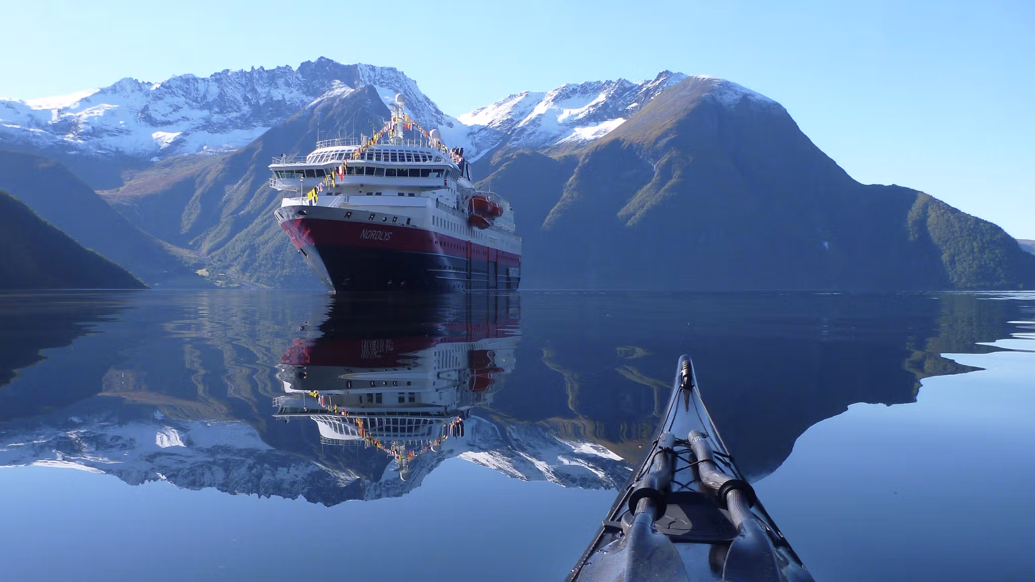 Le bateau MS Nordlys de la flotte Hurtigruten, vu d’un kayak sur le Hjørundfjorden en Norvège des Fjords