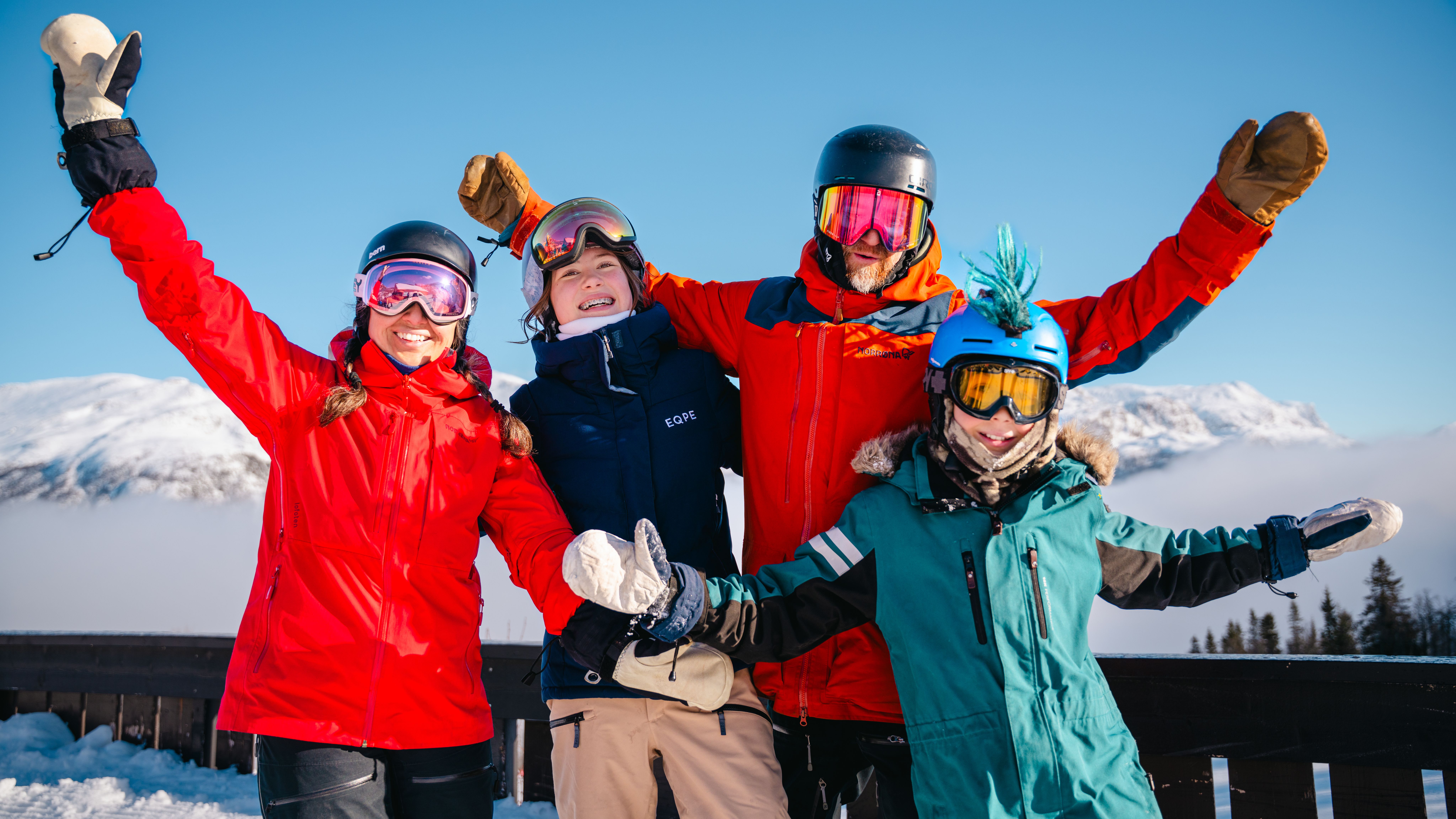 A family posing in front of a mountain at a ski resort.