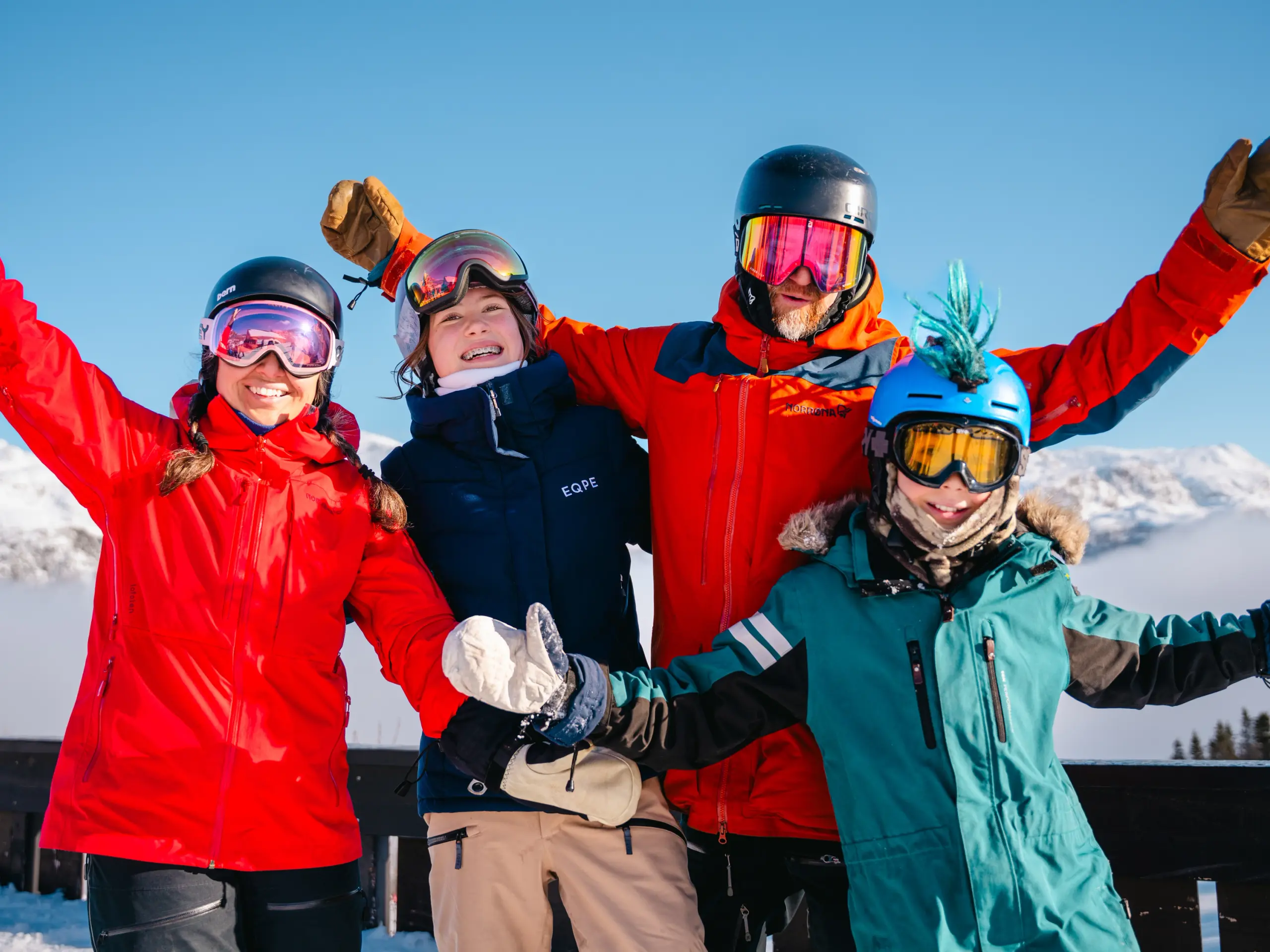 A family posing in front of a mountain at a ski resort.