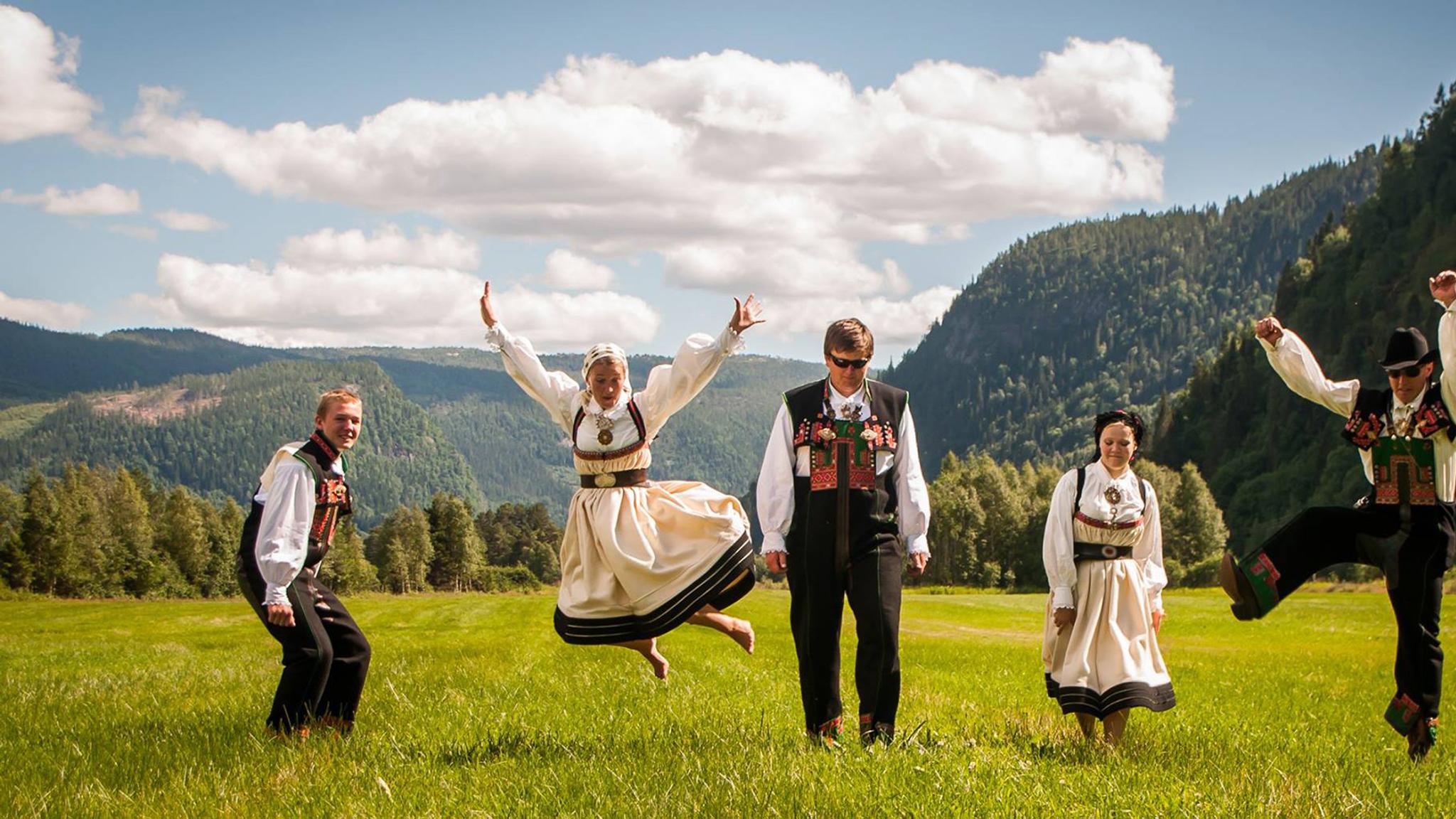 Fire mennesker i Setesdalsbunad danser i Setesdal på Sørlandet