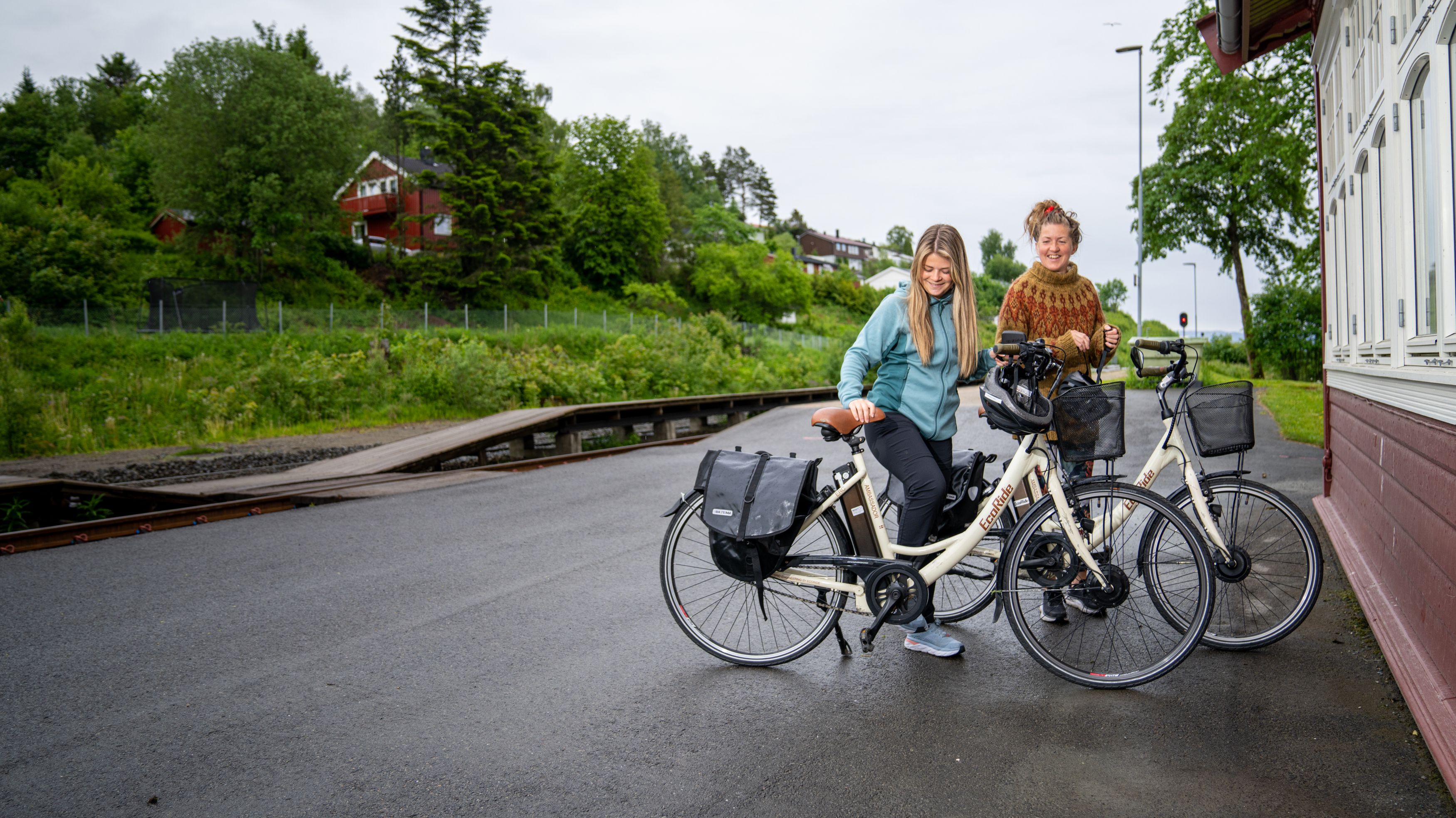 To damer plukker opp syklene sine på Røra Stasjon på Inderøy i Trøndelag
