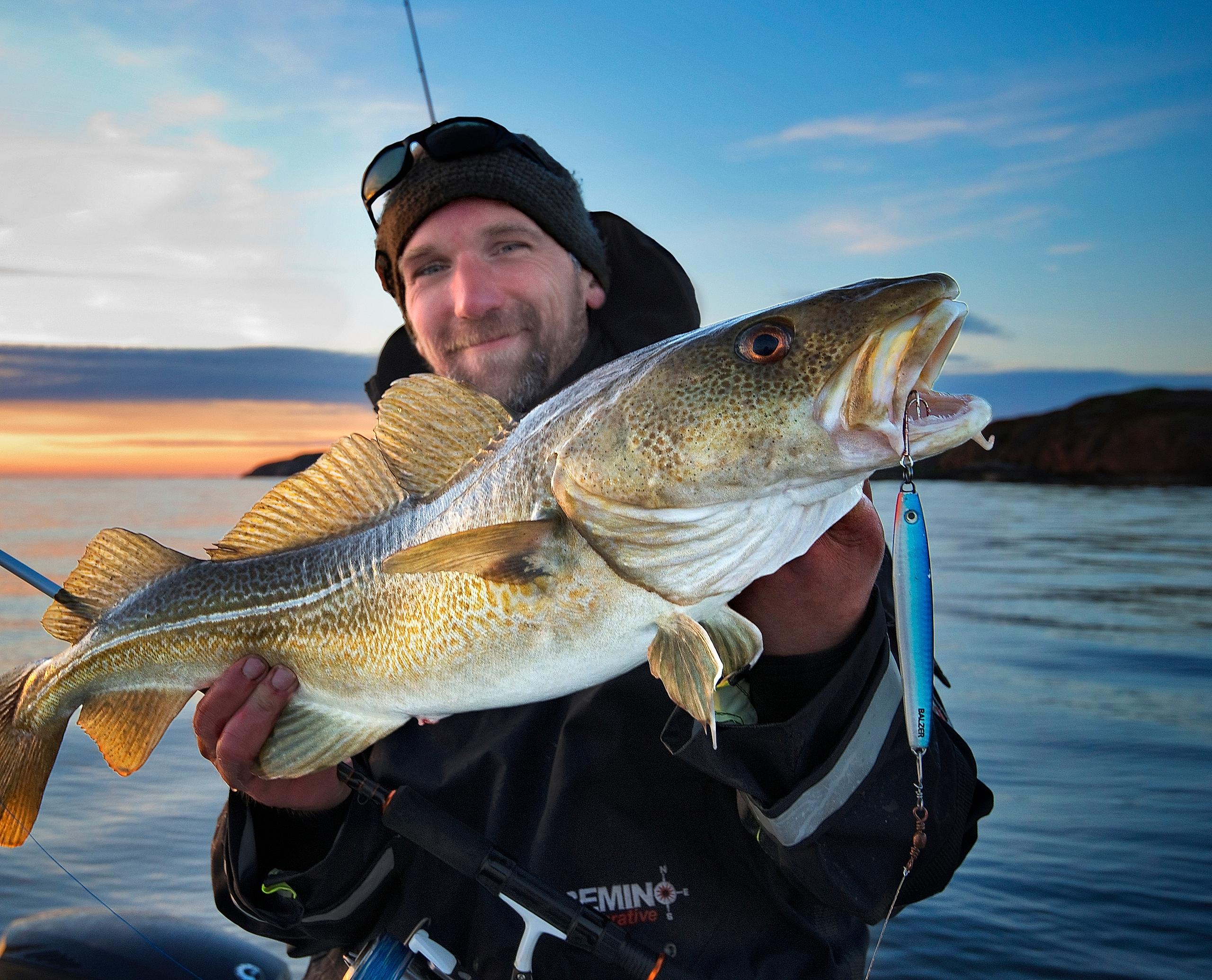 En mann older en fisk på Fosen, Trøndelag, Norge.