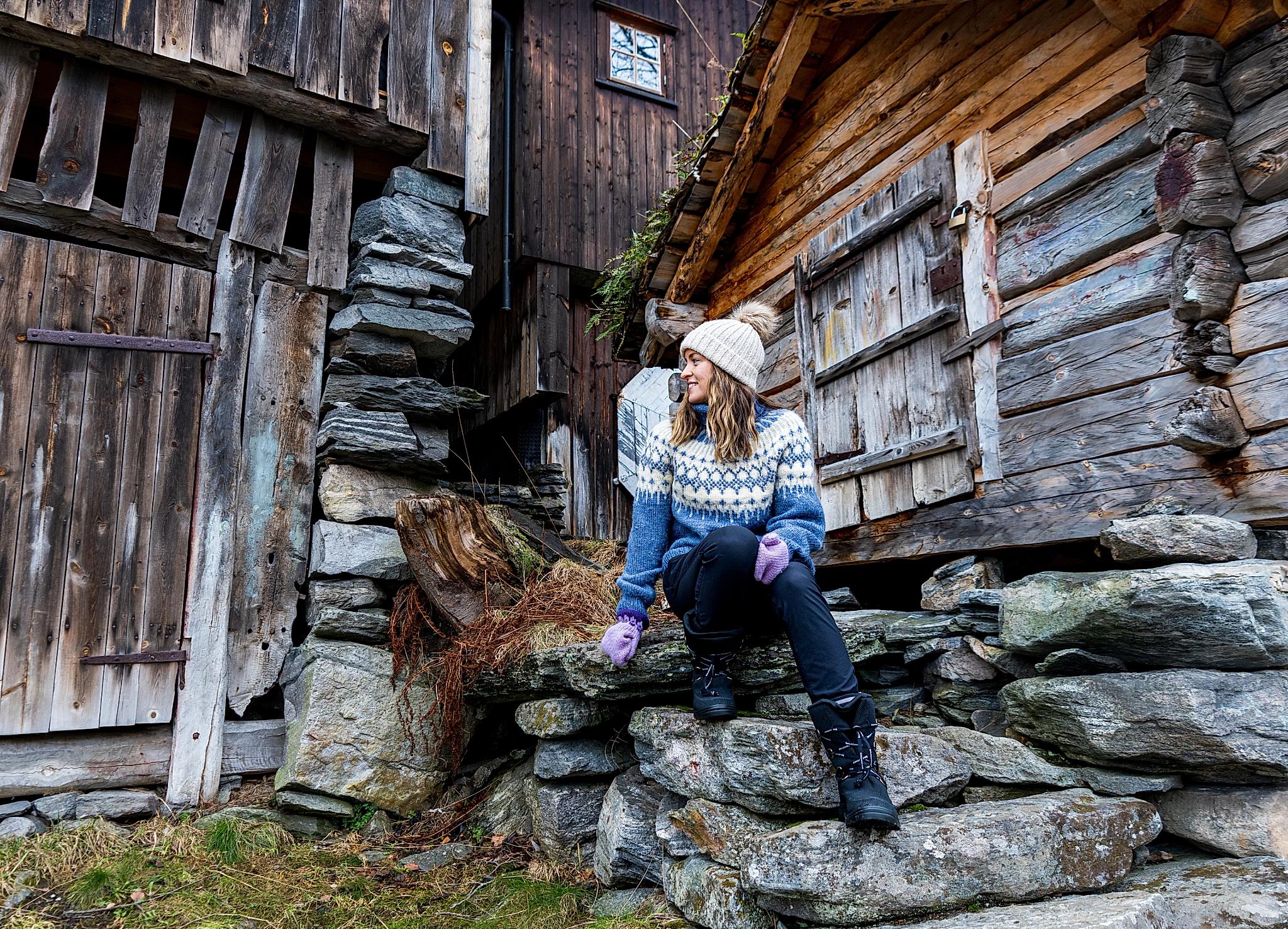 En kvinne sitter i en steintrapp i Geiranger