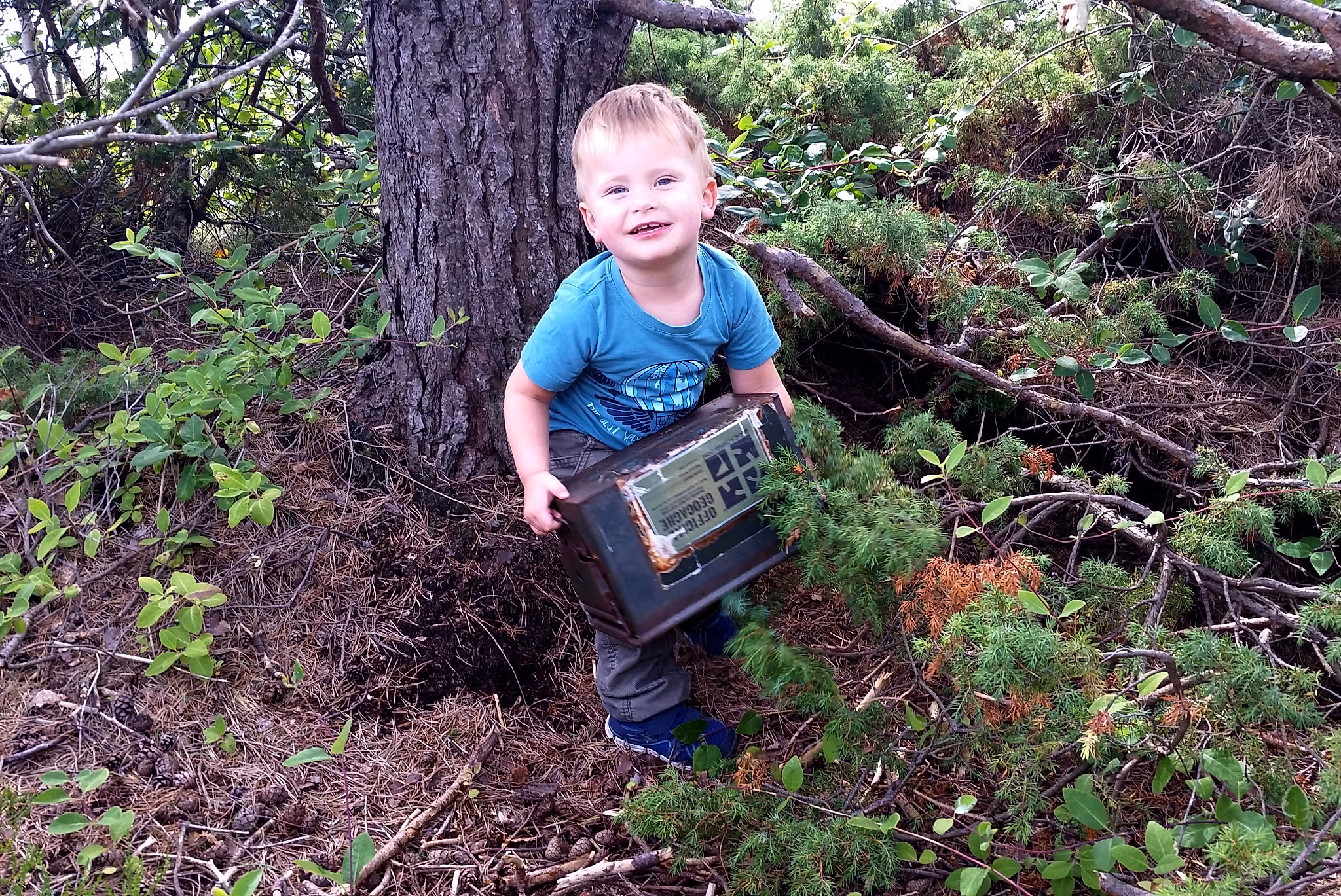 A boy geoaching next to a tree in Lyngor in Southern Norway