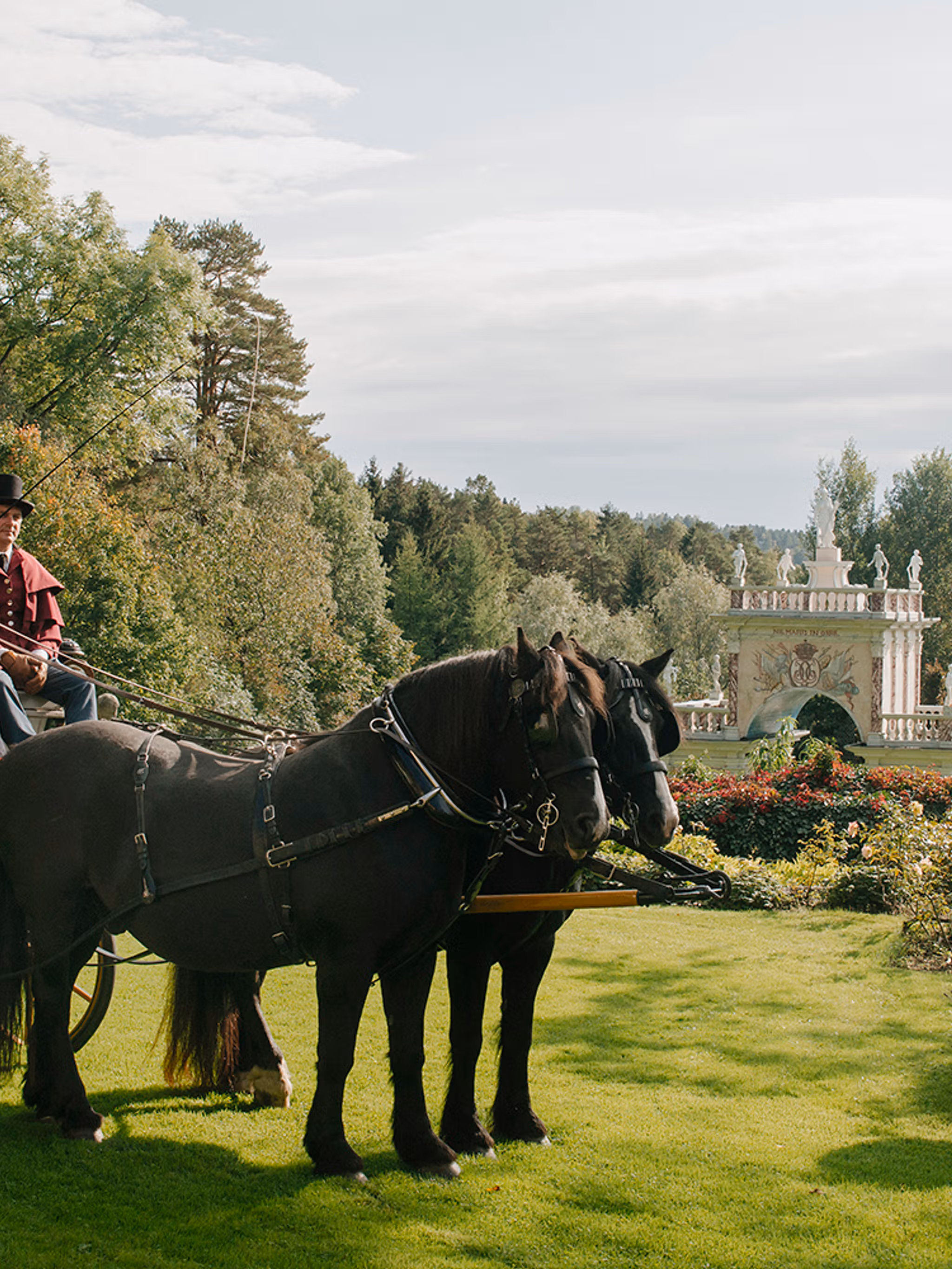 People in a horse-drawn carriage in Havlystparken at the culture destination Ramme Gård in Hvitsten by the Oslofjord in Eastern Norway