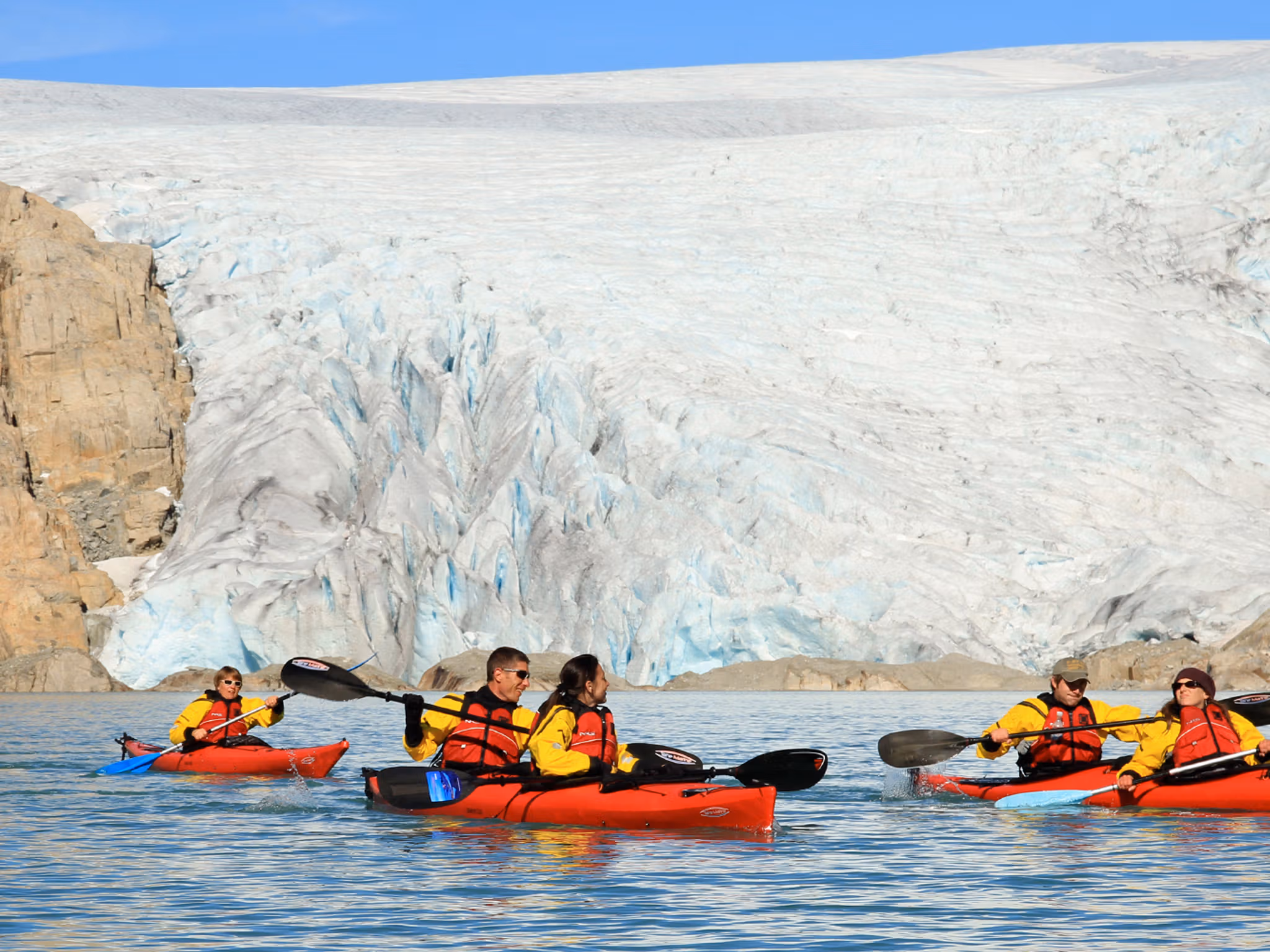 Five people kayaking close to the Folgefonna glacier in Kvinnherad