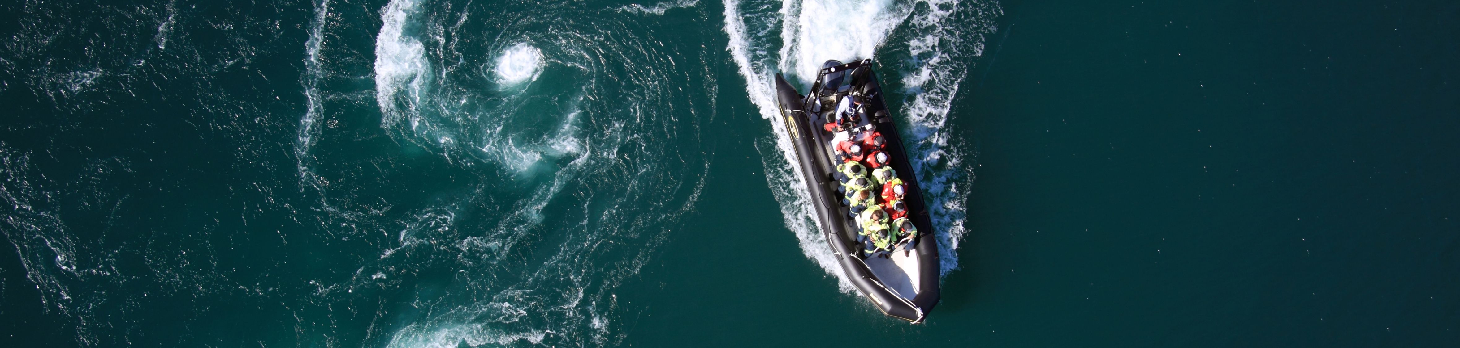 A RIB filled with people seen from above on Saltstraumen in Bodø, Northern Norway