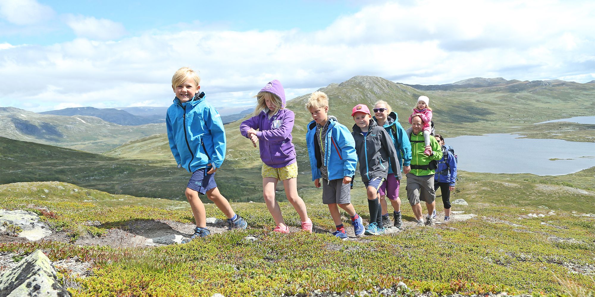 Eine Gruppe aus Erwachsenen und Kindern beim Wandern in den Bergen von Hemsedal, Ostnorwegen