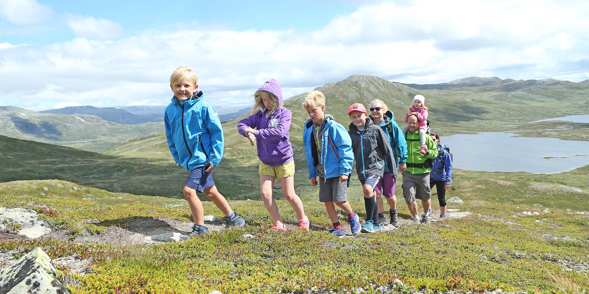 Eine Gruppe aus Erwachsenen und Kindern beim Wandern in den Bergen von Hemsedal, Ostnorwegen