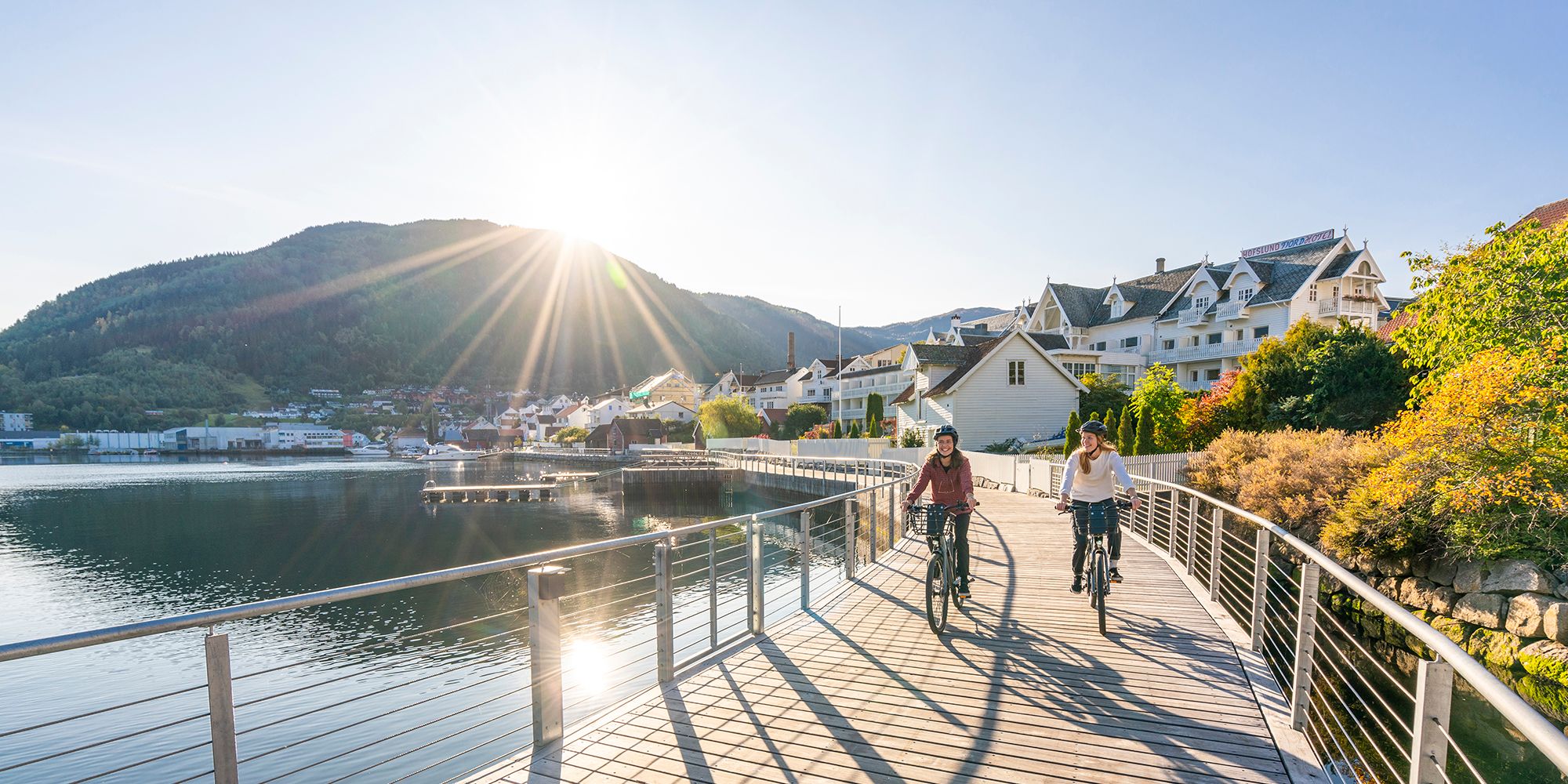 Planlegg reisen til Sognefjorden: To personer sykler langs Fjordstien i Sogndal ved Sognefjorden på Vestlandet